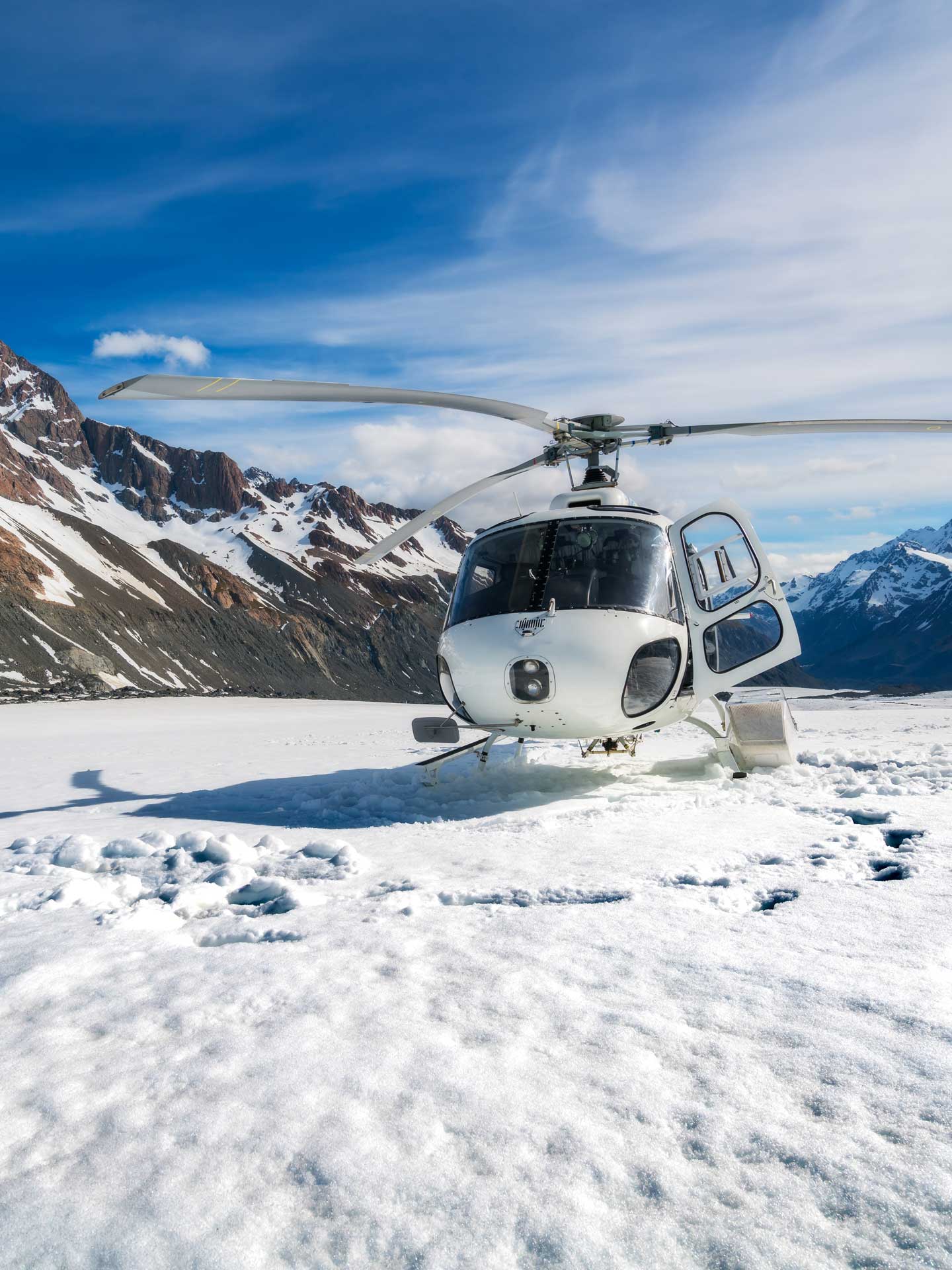A white helicopter parked on white snow