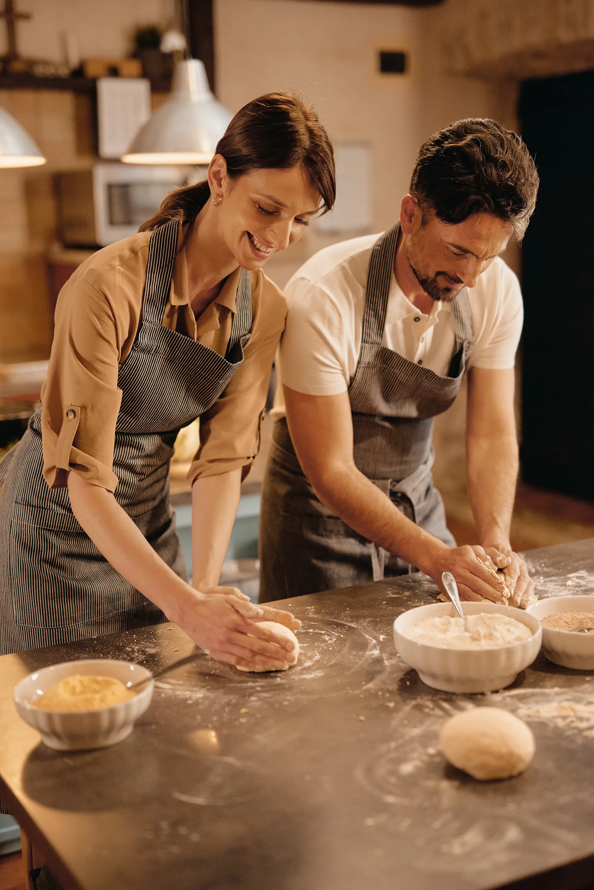 Two people kneading dough on a kitchen surface at Konavle in Croatia