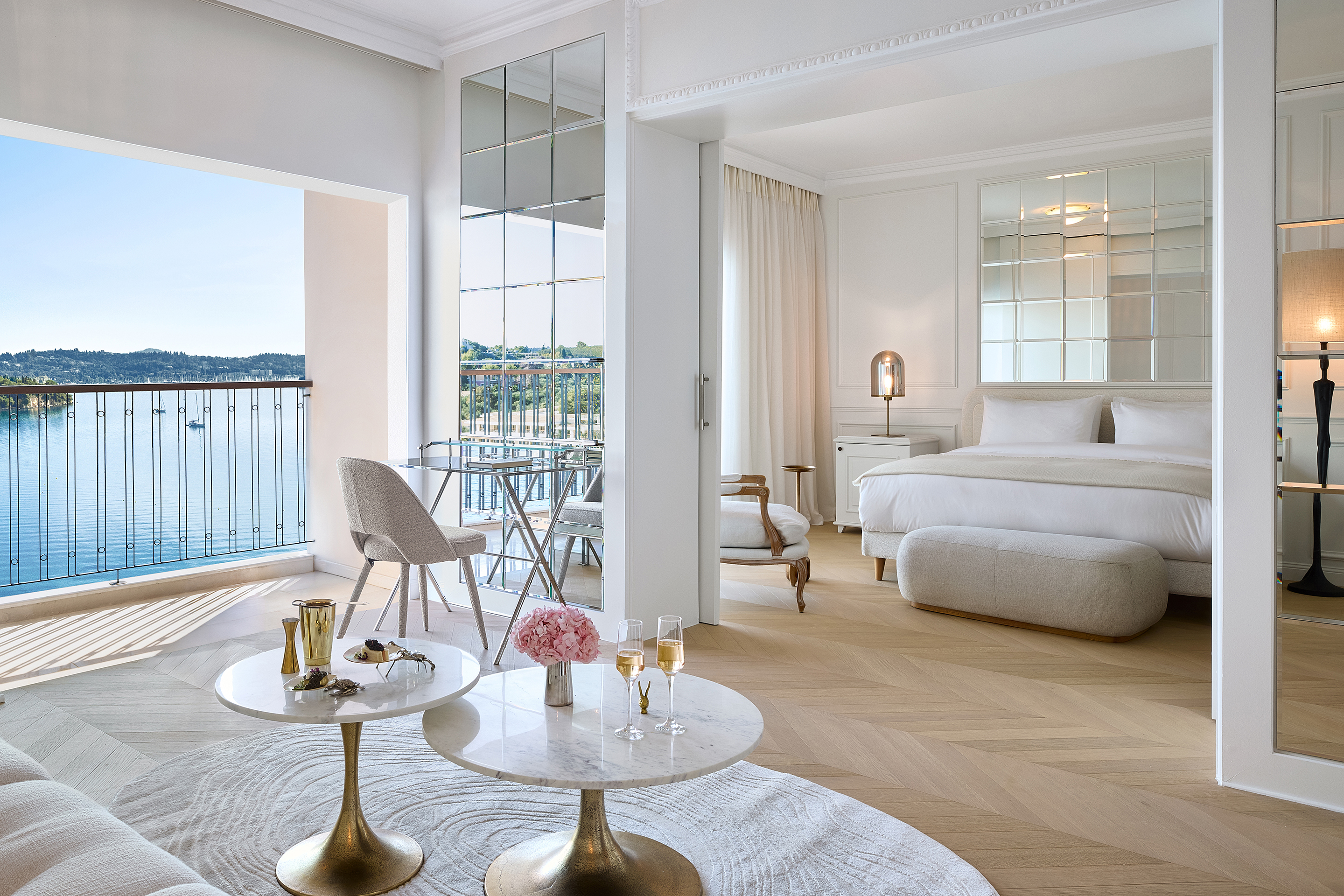 Elegant sea-view suite at Grecotel Corfu Imperial featuring a spacious bedroom and stylish interior design.