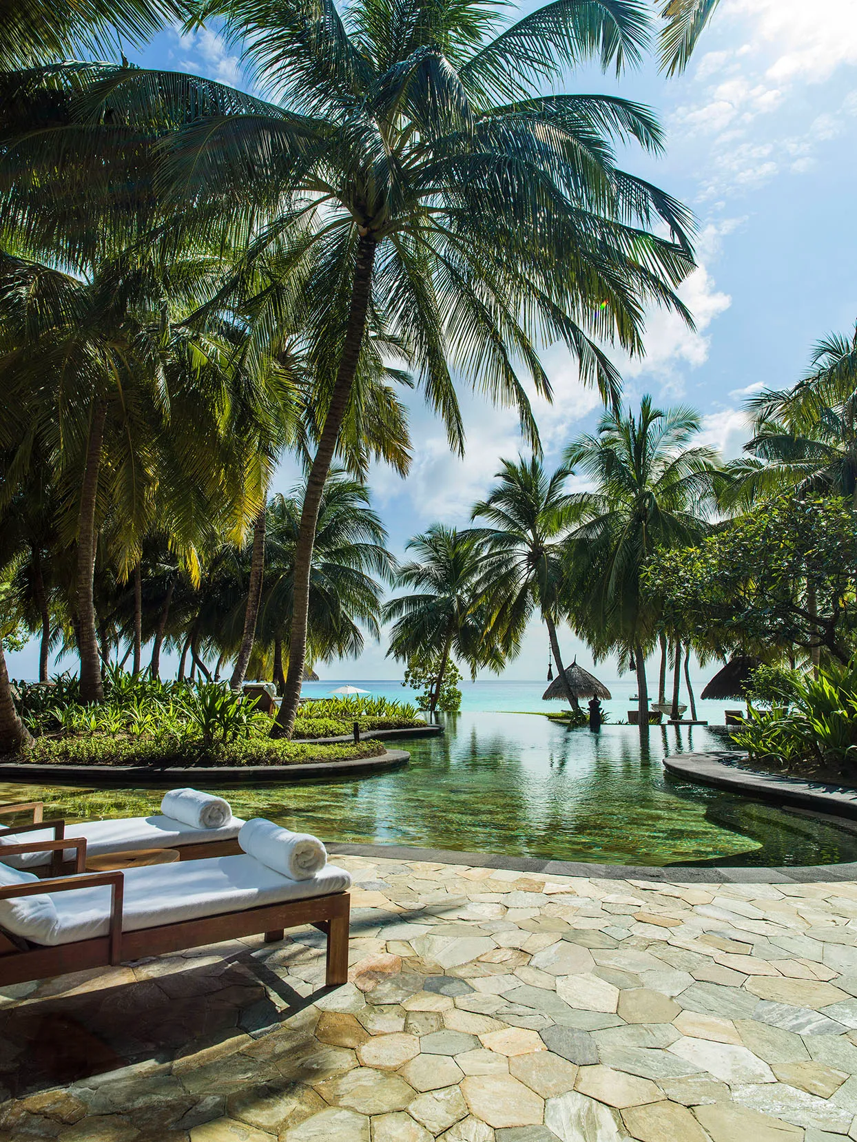 Two sun loungers beside the main pool at One&Only Reethi Rah, Maldives