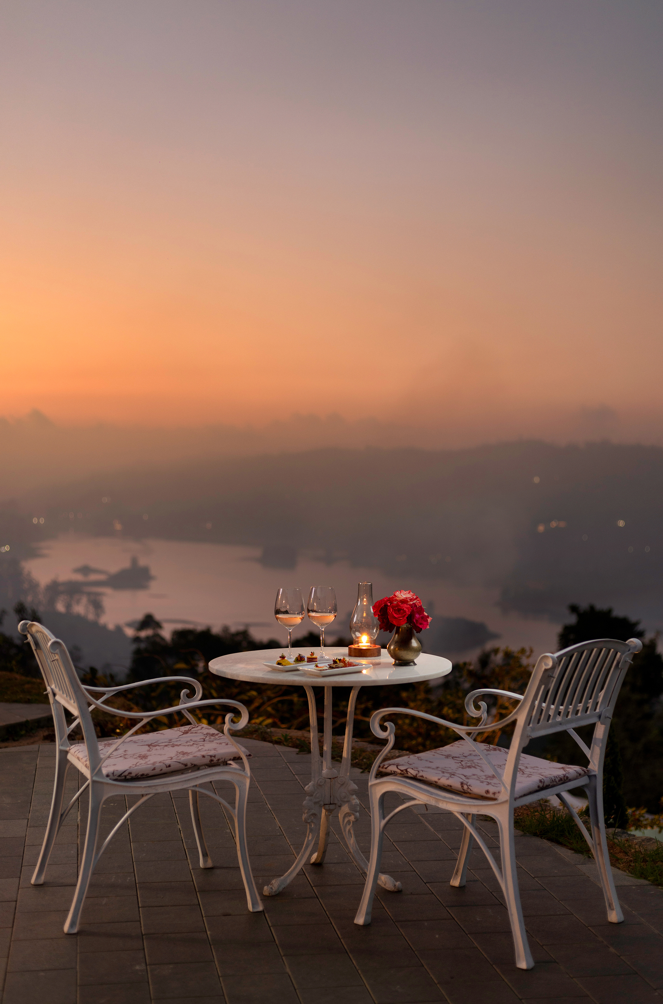 A pretty white bistro table and chairs set for sunset drinks overlooking the reservoir at Uga Halloowella