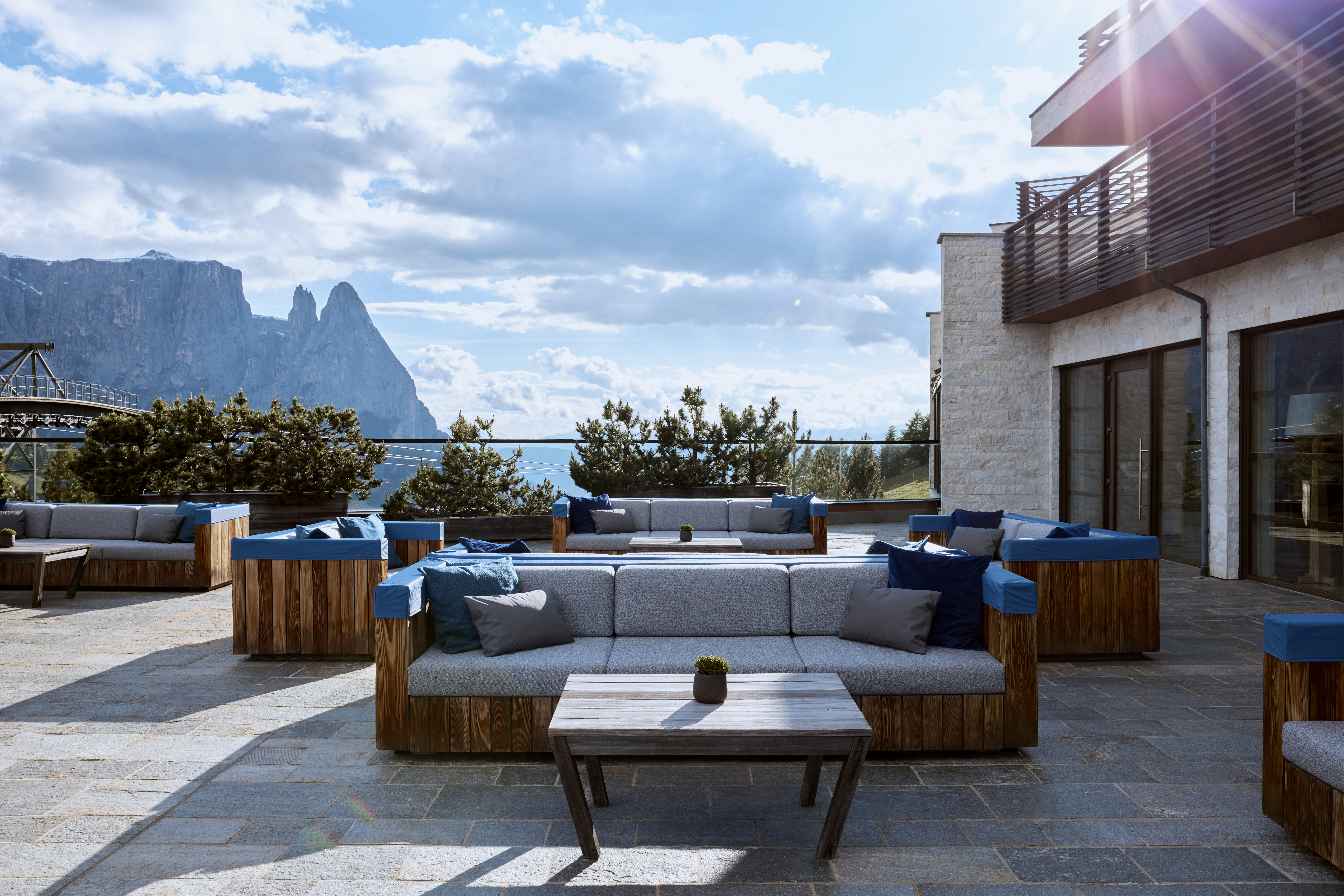 An outdoor terrace with modern furniture and a mountain view, highlighting a luxurious relaxation area.
