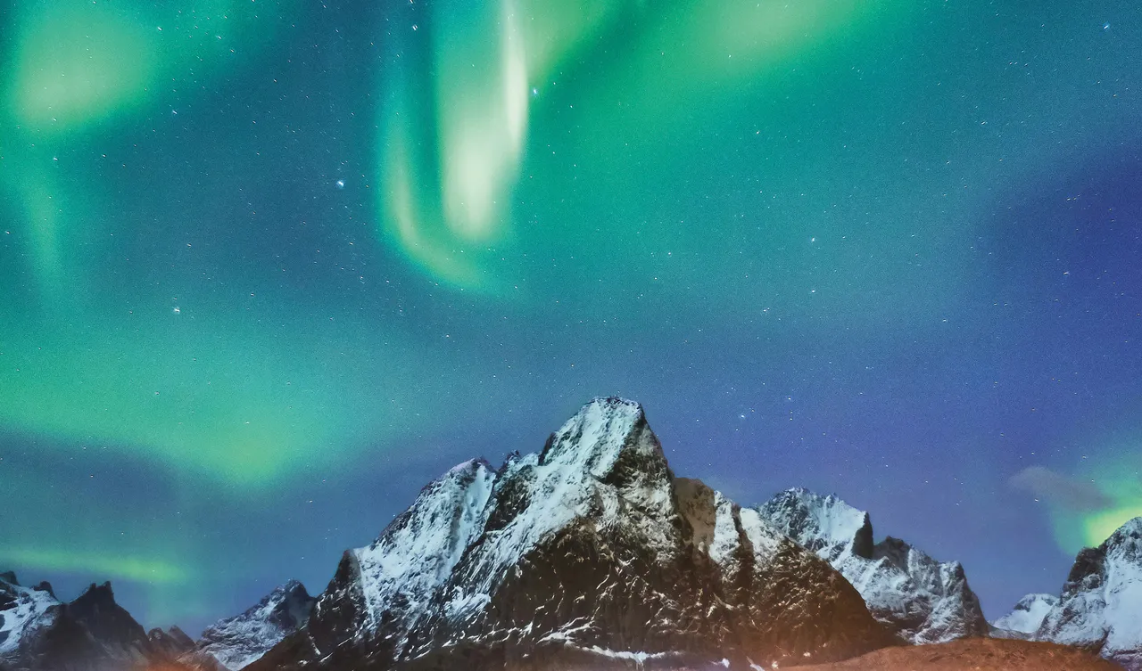 The northern lights seen above a mountaintop 