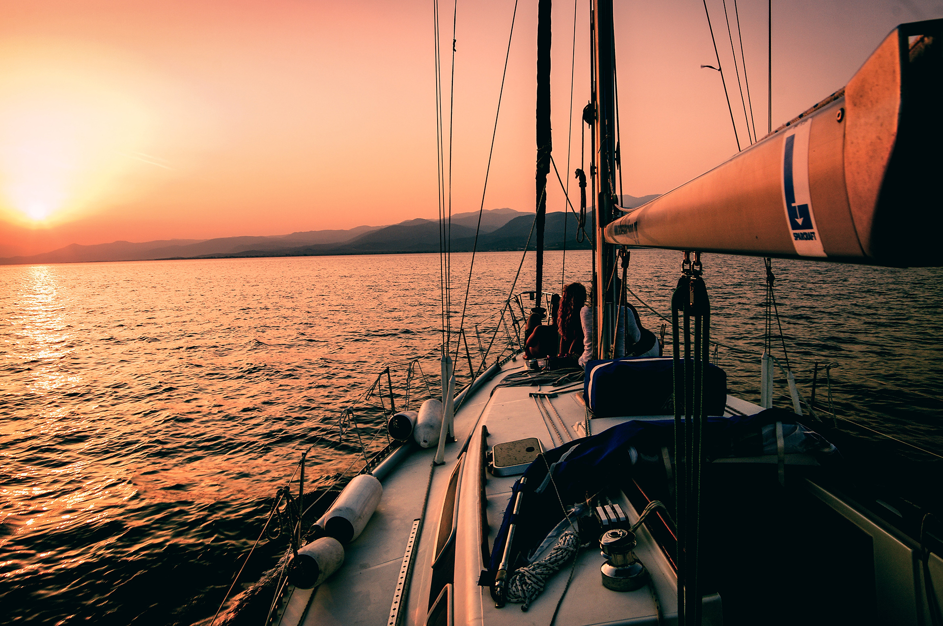 White and black sailboat during sunset