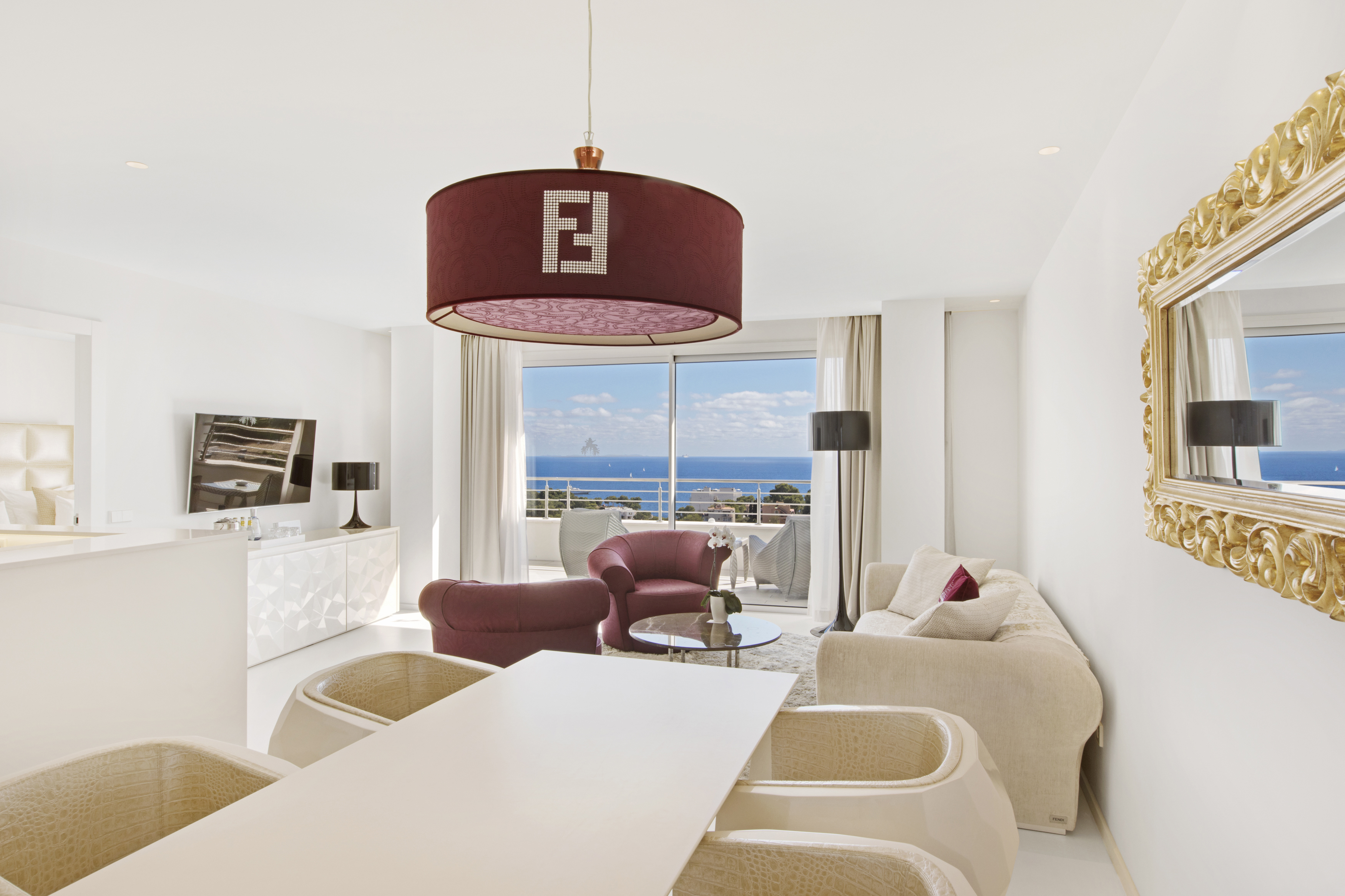 Modern living room at Portals Hills in Mallorca with ocean views, stylish furniture, and a Fendi chandelier centerpiece.
