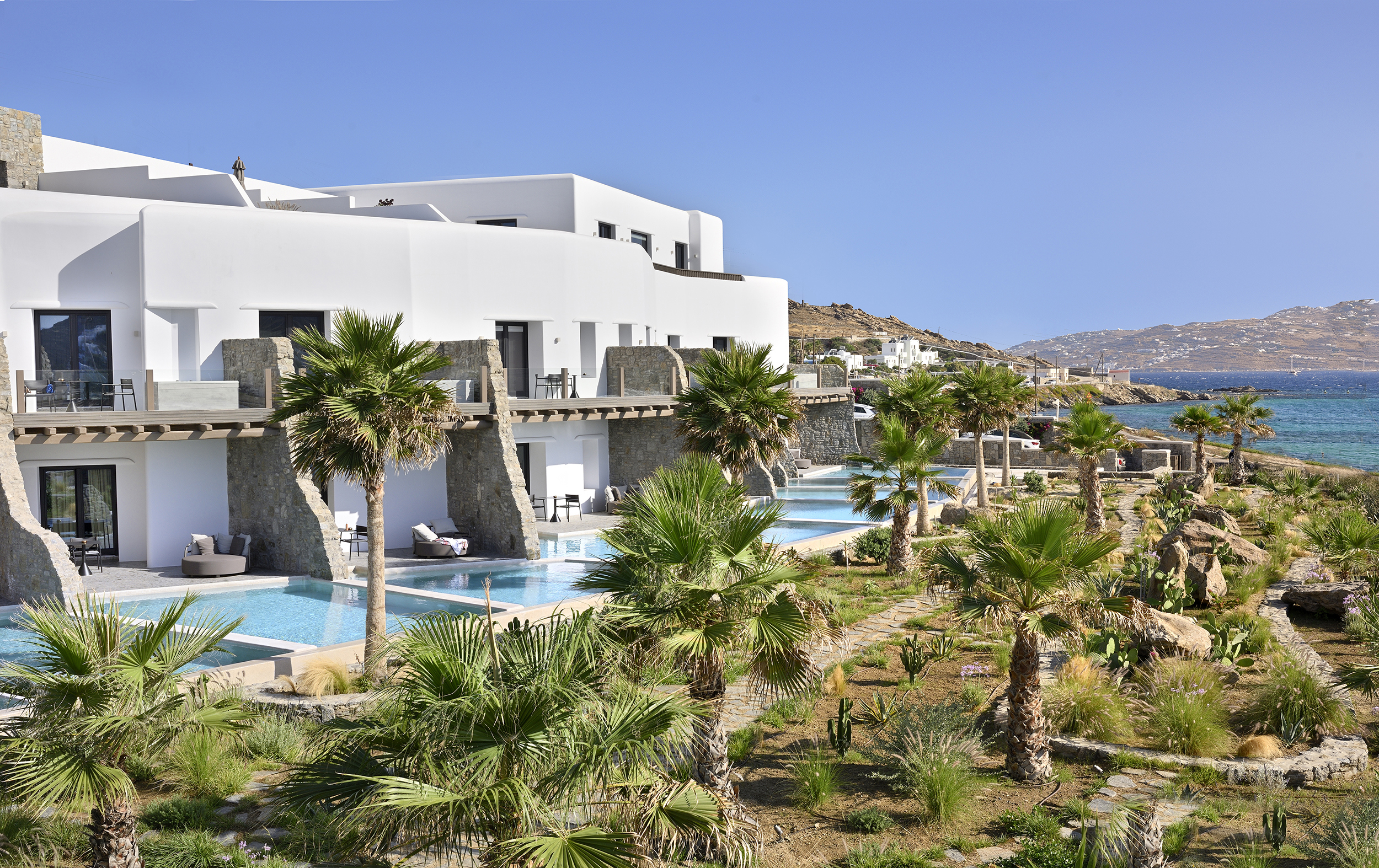 Row of pool suites overlooking the bay at Aeonic Suites & Spa