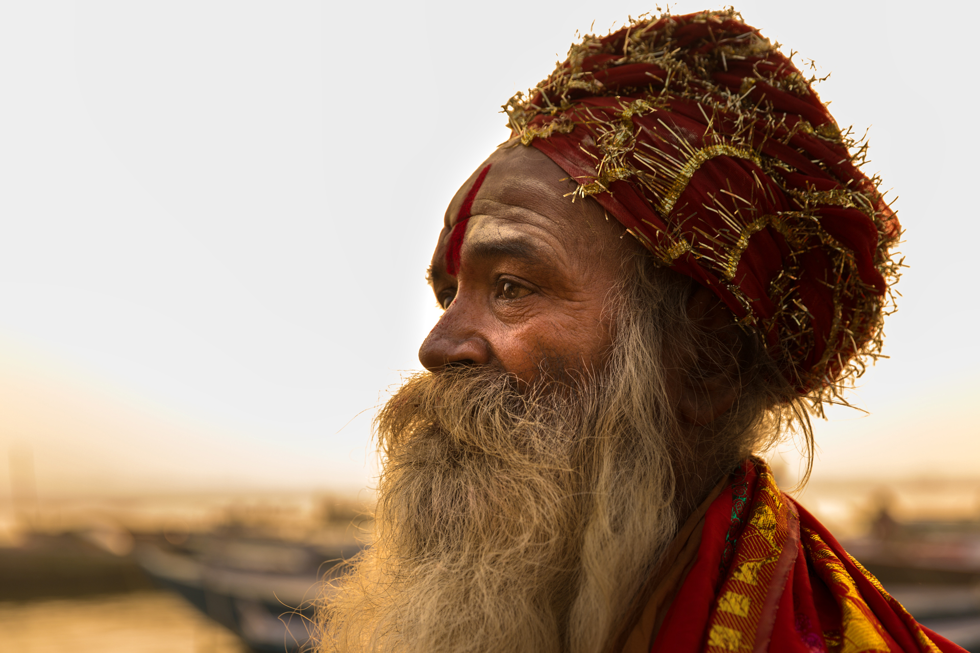 a close up of a person with a long beard and red turban