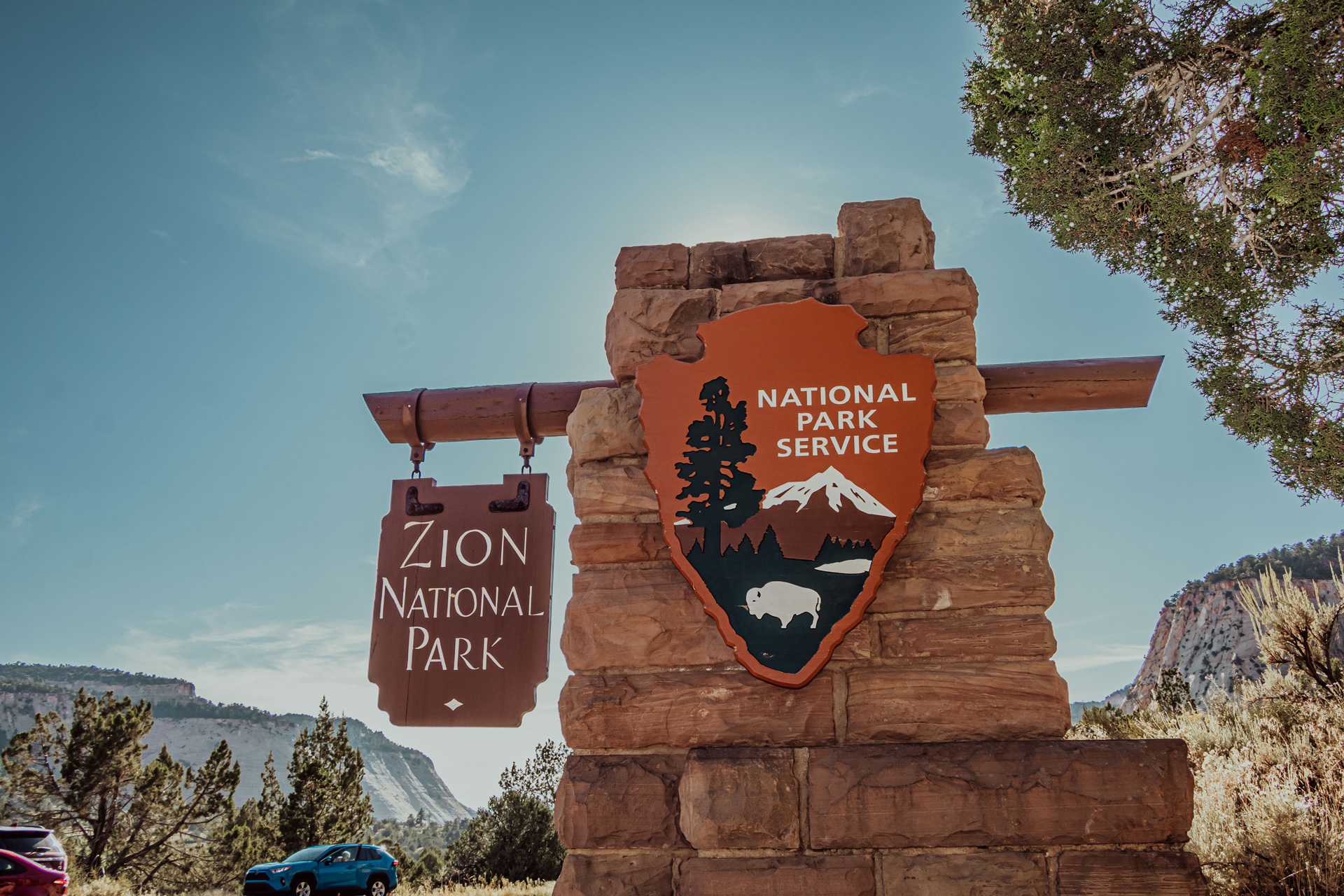 Two signs displaying the entrance of the Zion National Park