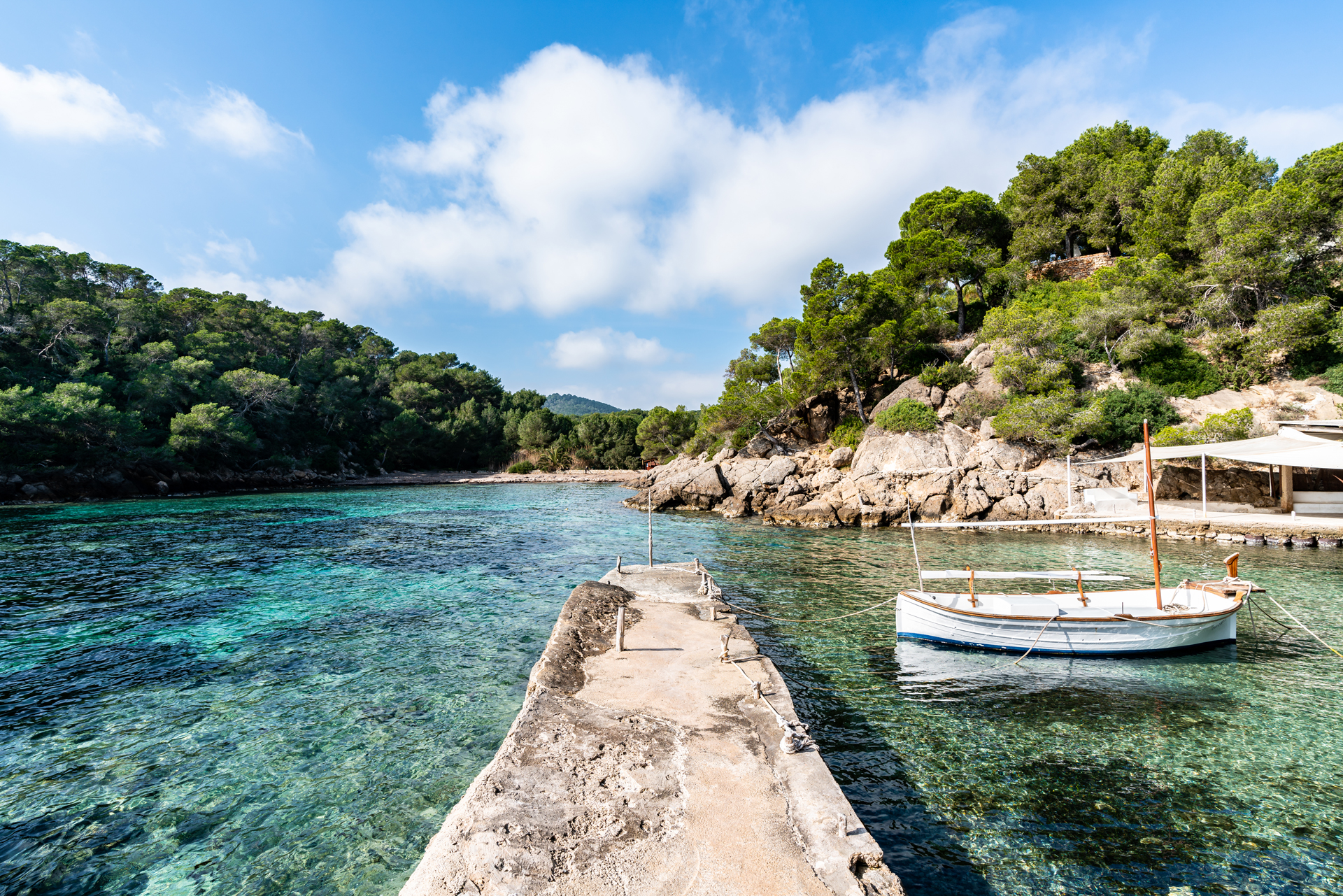 Cala Mastella beach stone pier and docked boat