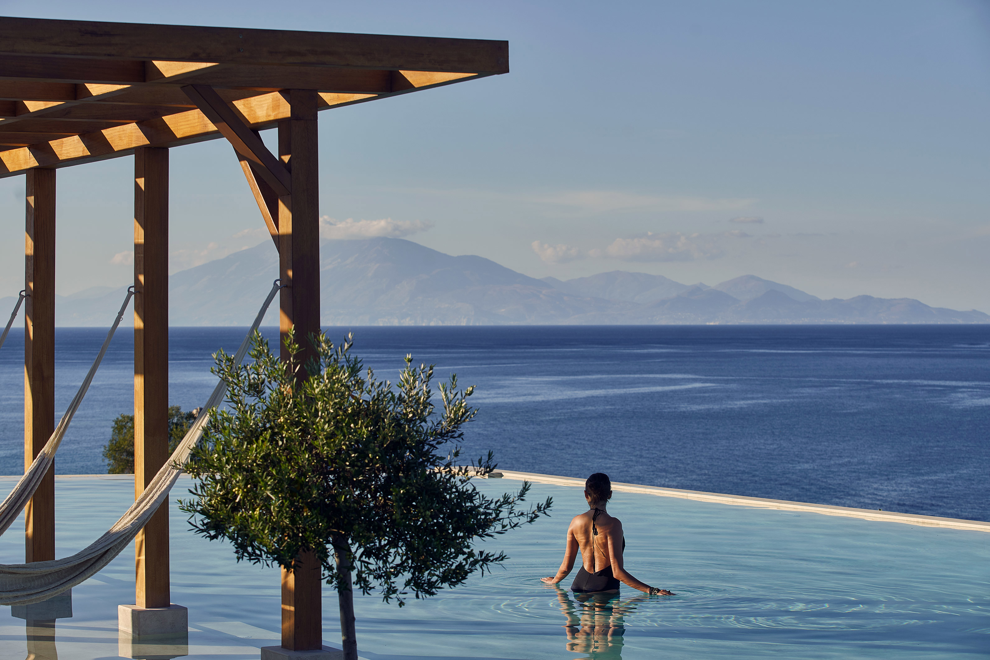Woman in black swimsuit in the infinity pool at Lesante Cape