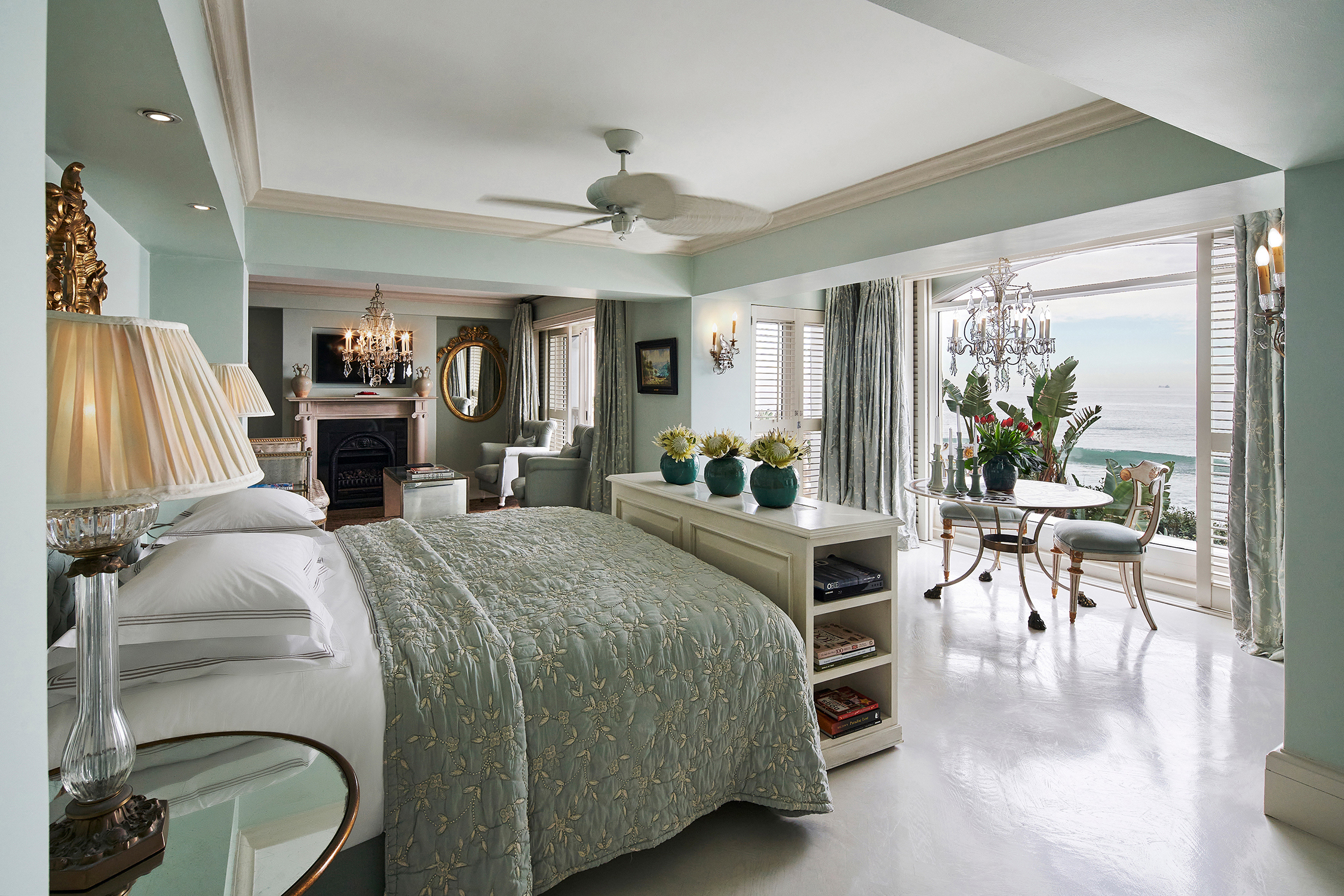 A Presidential Suite bedroom at The Oyster Box featuirng pale blue decor, a plush bed and sliding doors with a view of the ocean