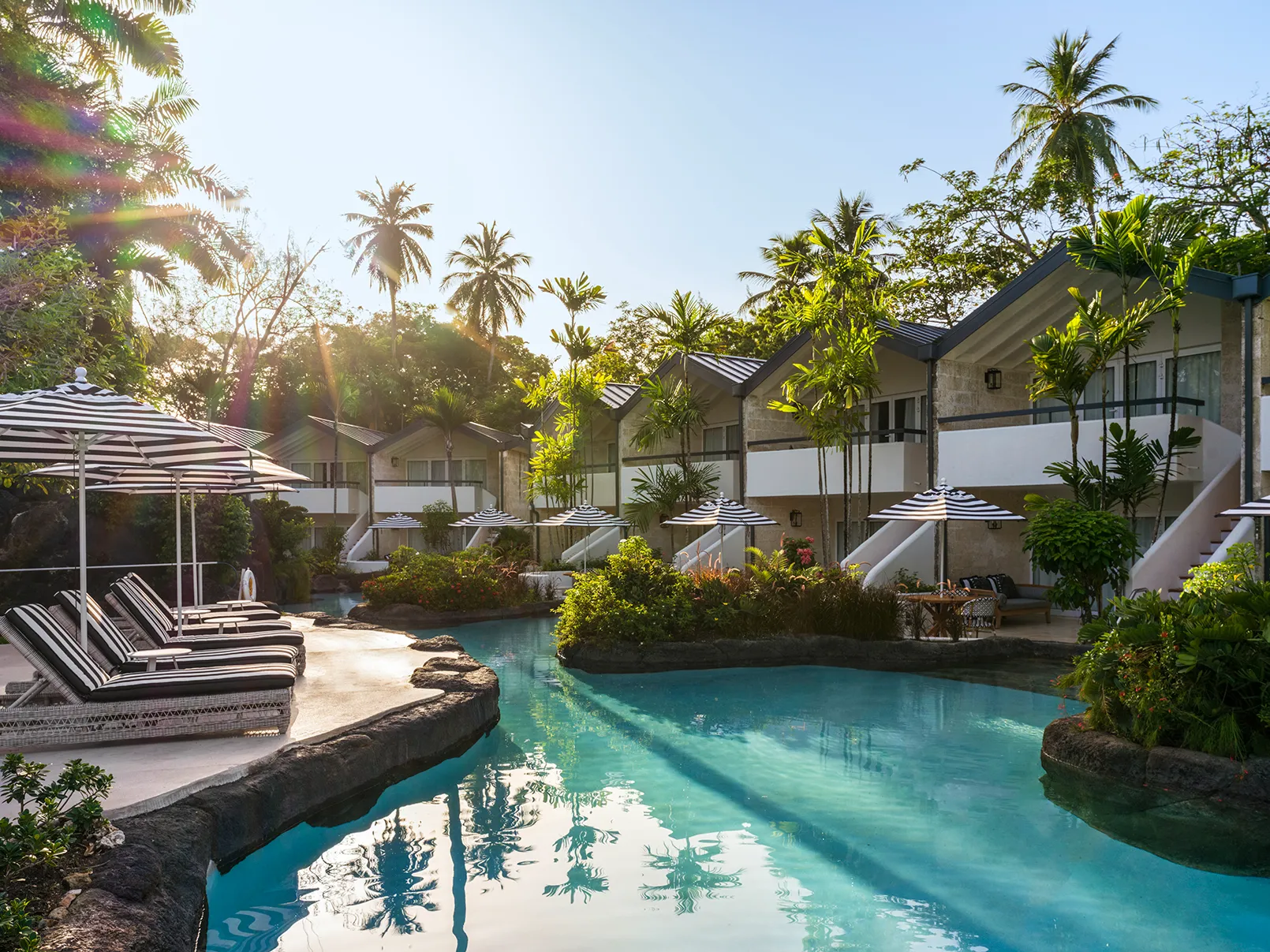 Caribbean, Barbados, Colony Club, pool fringed by sun loungers on one side, and private verandas on the other