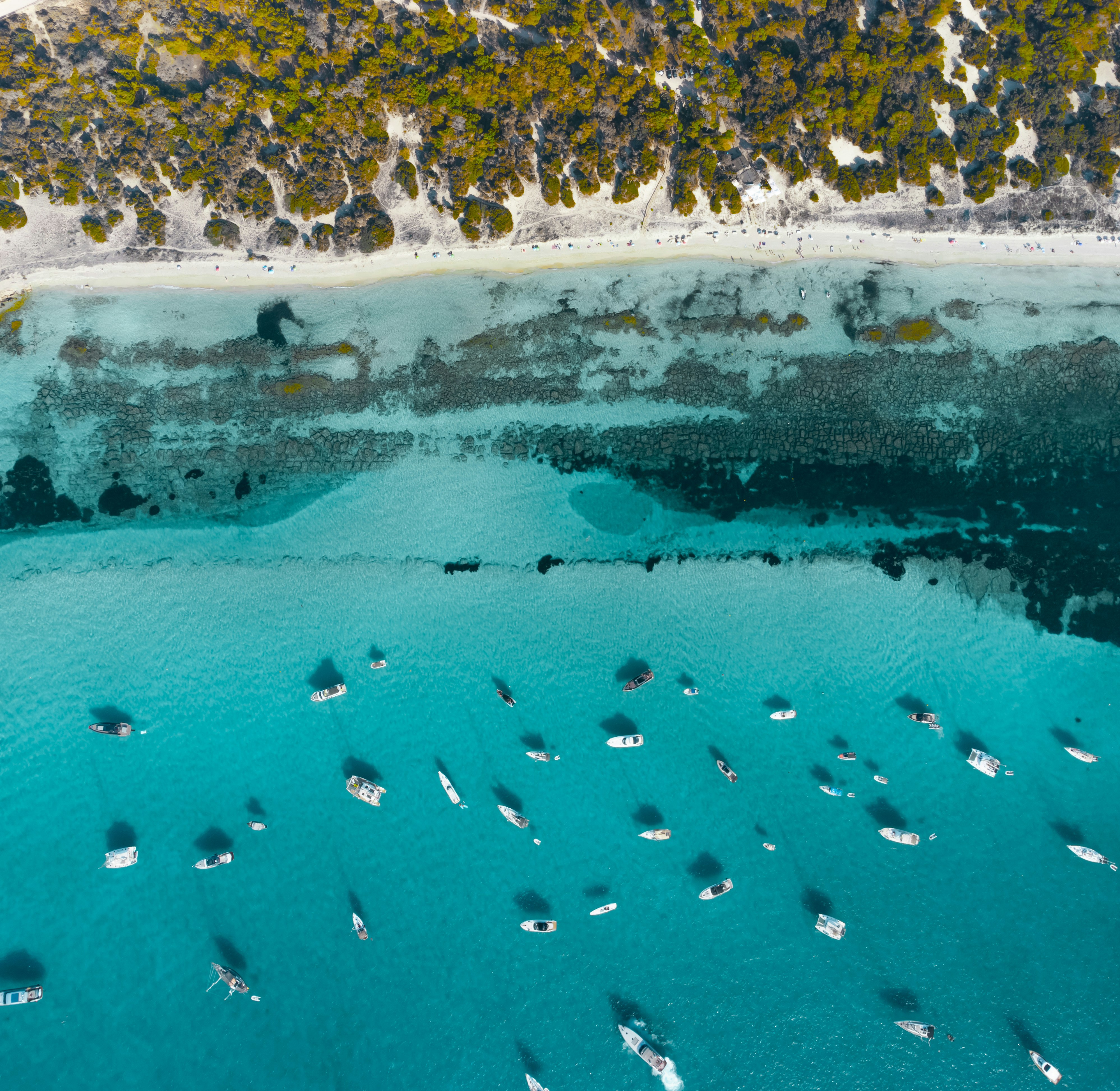 An aerial view of the coastline of Formentera with boats anchored in the ocean