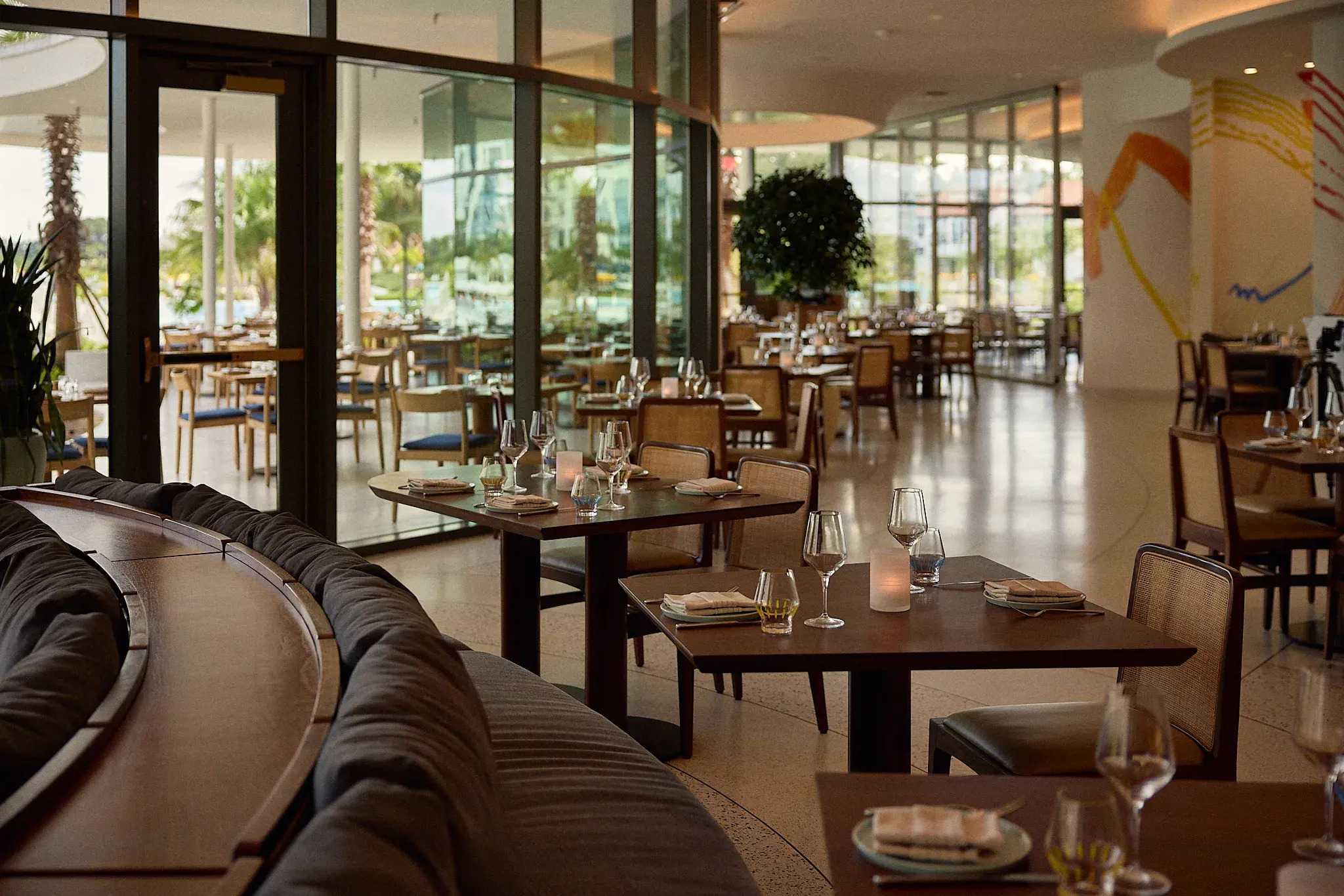 Elegant Sophia's Restaurant at Conrad Orlando in Florida featuring modern décor, floor‑to‑ceiling windows, and beautifully set tables.