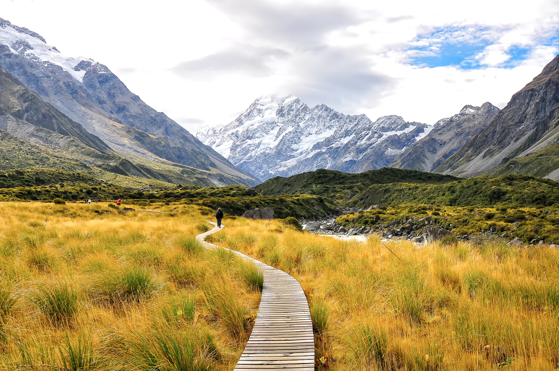 A person walking on a small wooden walkway through Aoraki Mount Cook National Park