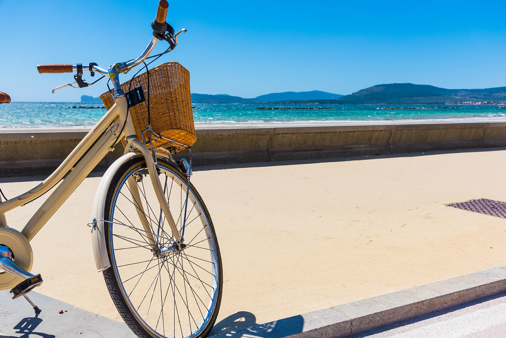 A bike with a basket parked with the sea in the background in Sardinia 