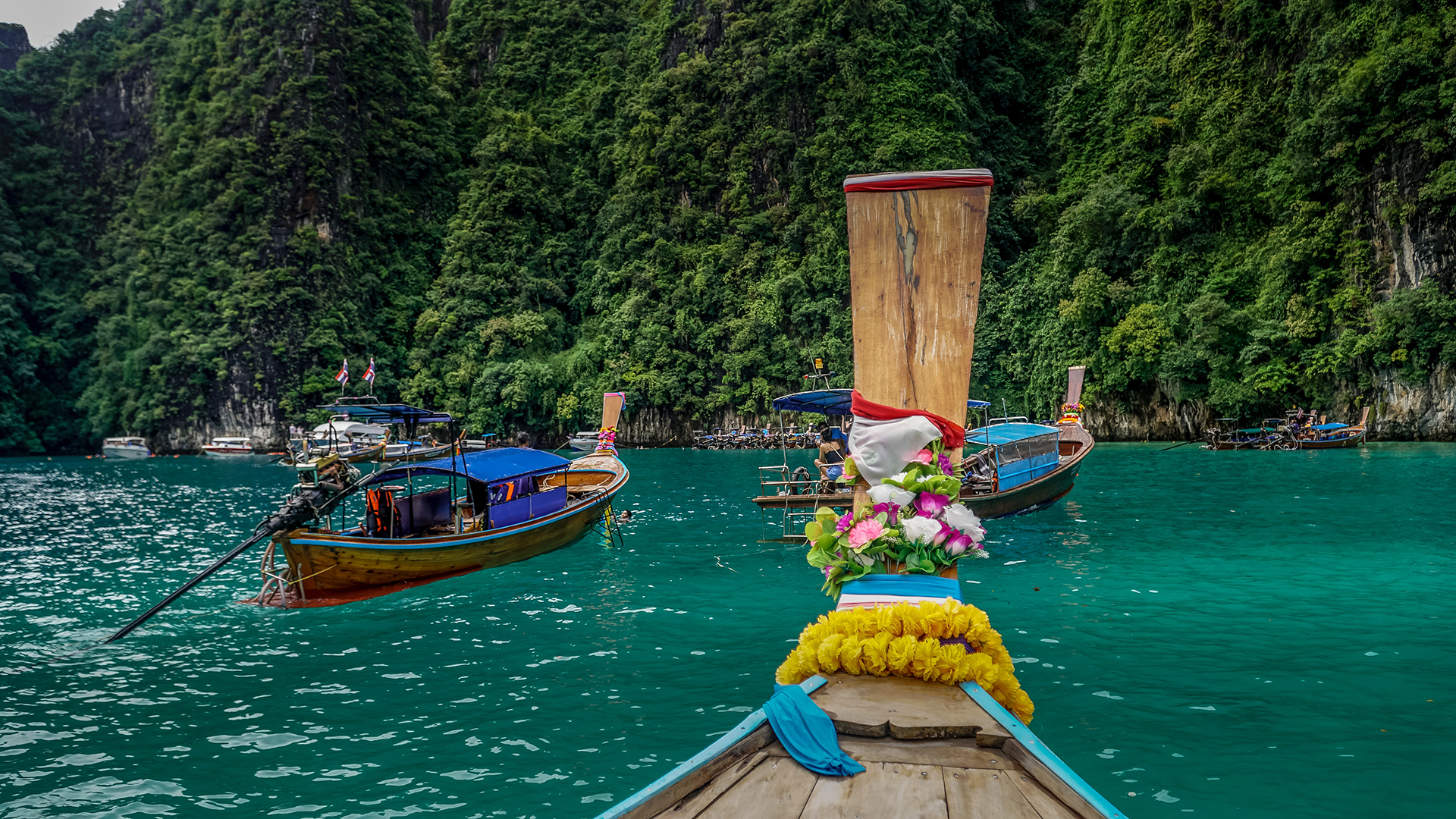 A row of boats floating on top of a body of water