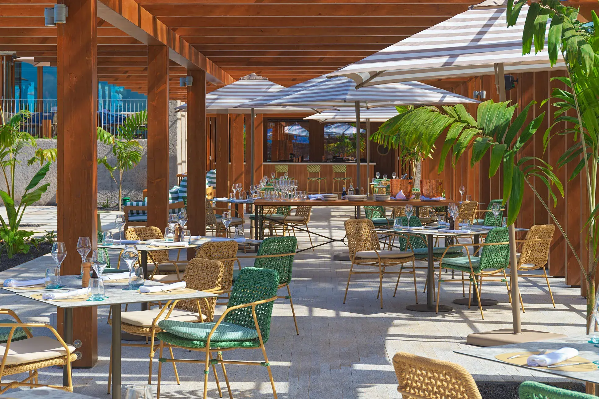 Outdoor poolside restaurant at Gran Hotel Taoro in Tenerife featuring shaded seating, tropical plants and a relaxed open‑air dining atmosphere.