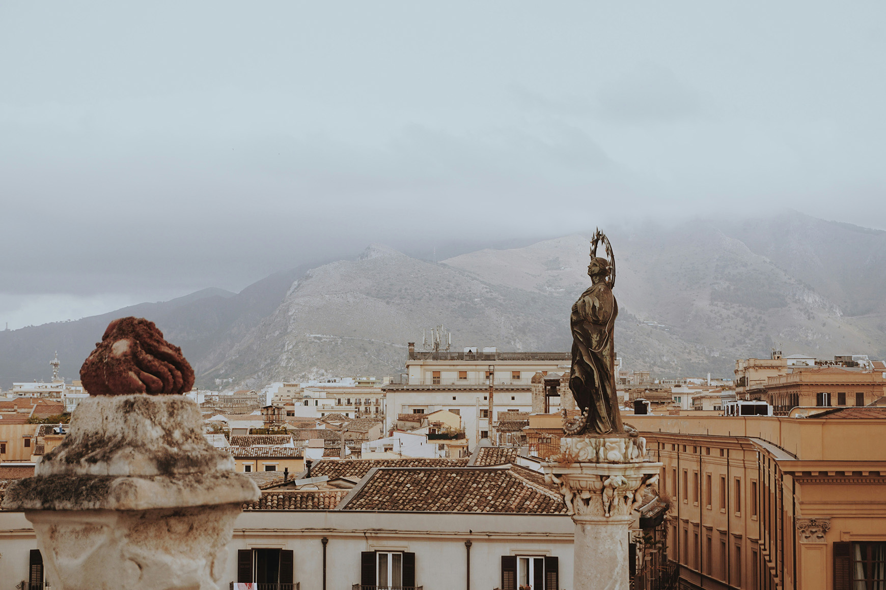 Europe, Italy, Sicily, Palermo rooftops and statue on a cloudy day