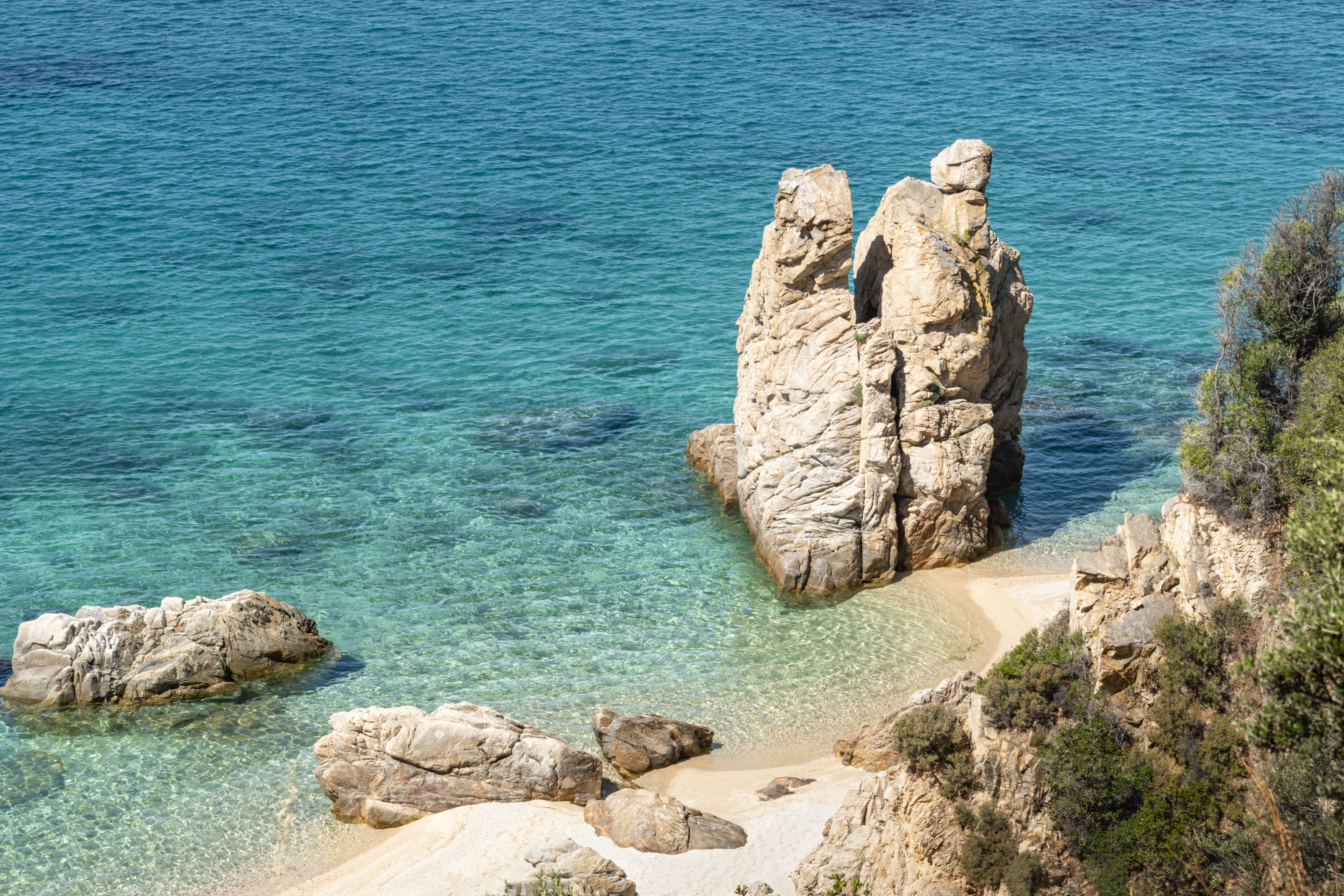 Bird's eye view of of a rocky beach and turquoise blue sea in Halkidiki, Greece