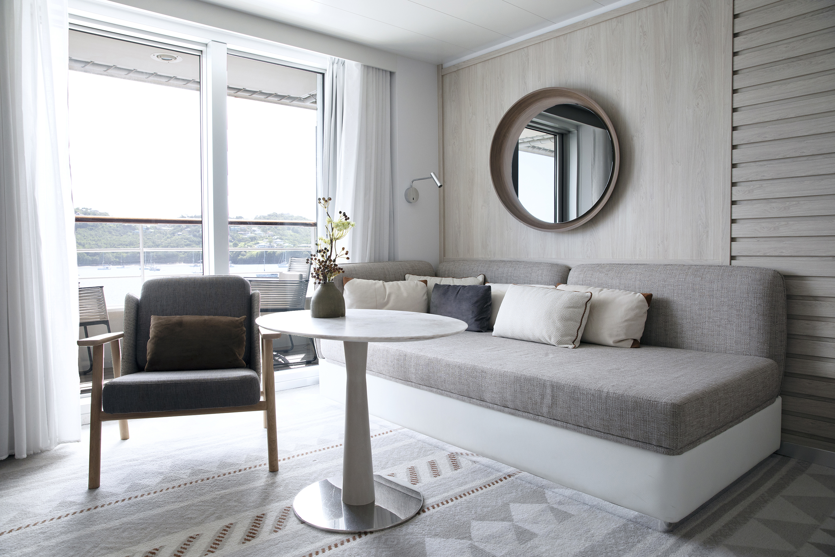 The relaxing lounge area of a Suite aboard PONANT Le Dumont d'Urville decorated in neutral tones