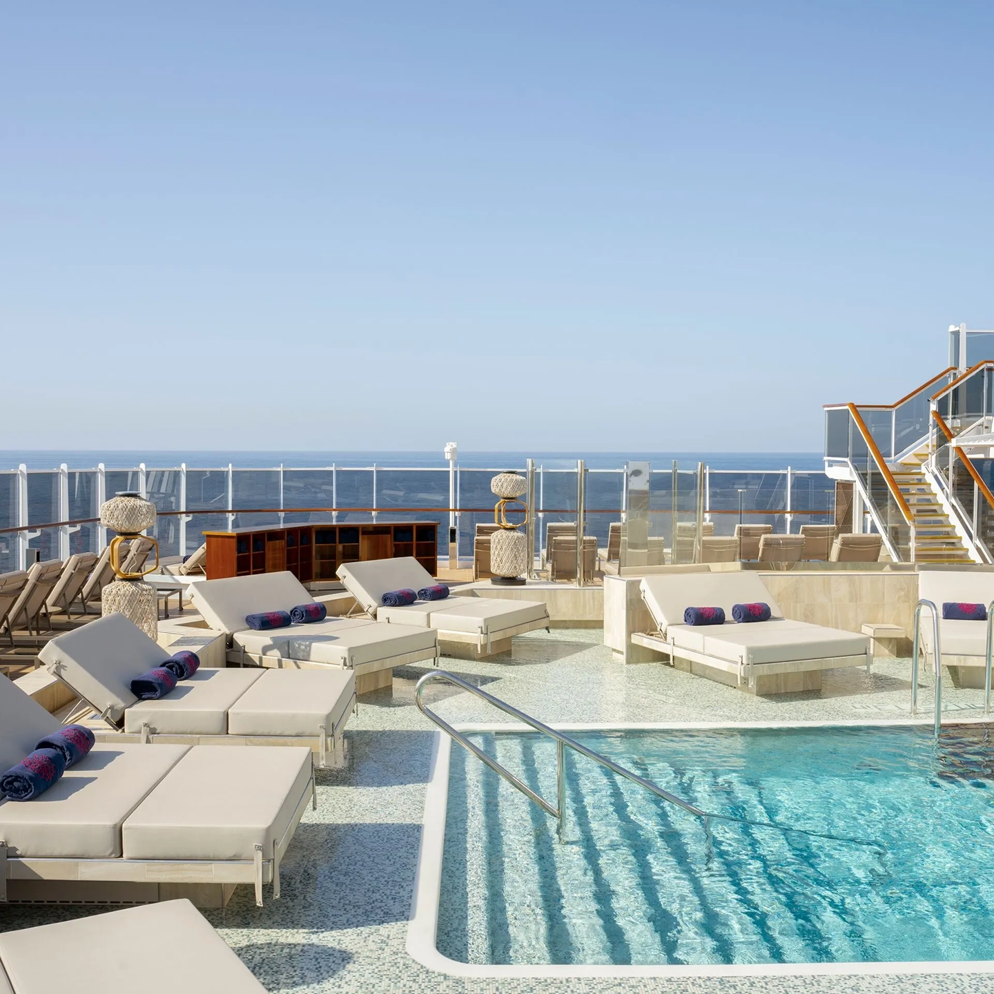 Outdoor pool and day beds on Explora I cruise ship