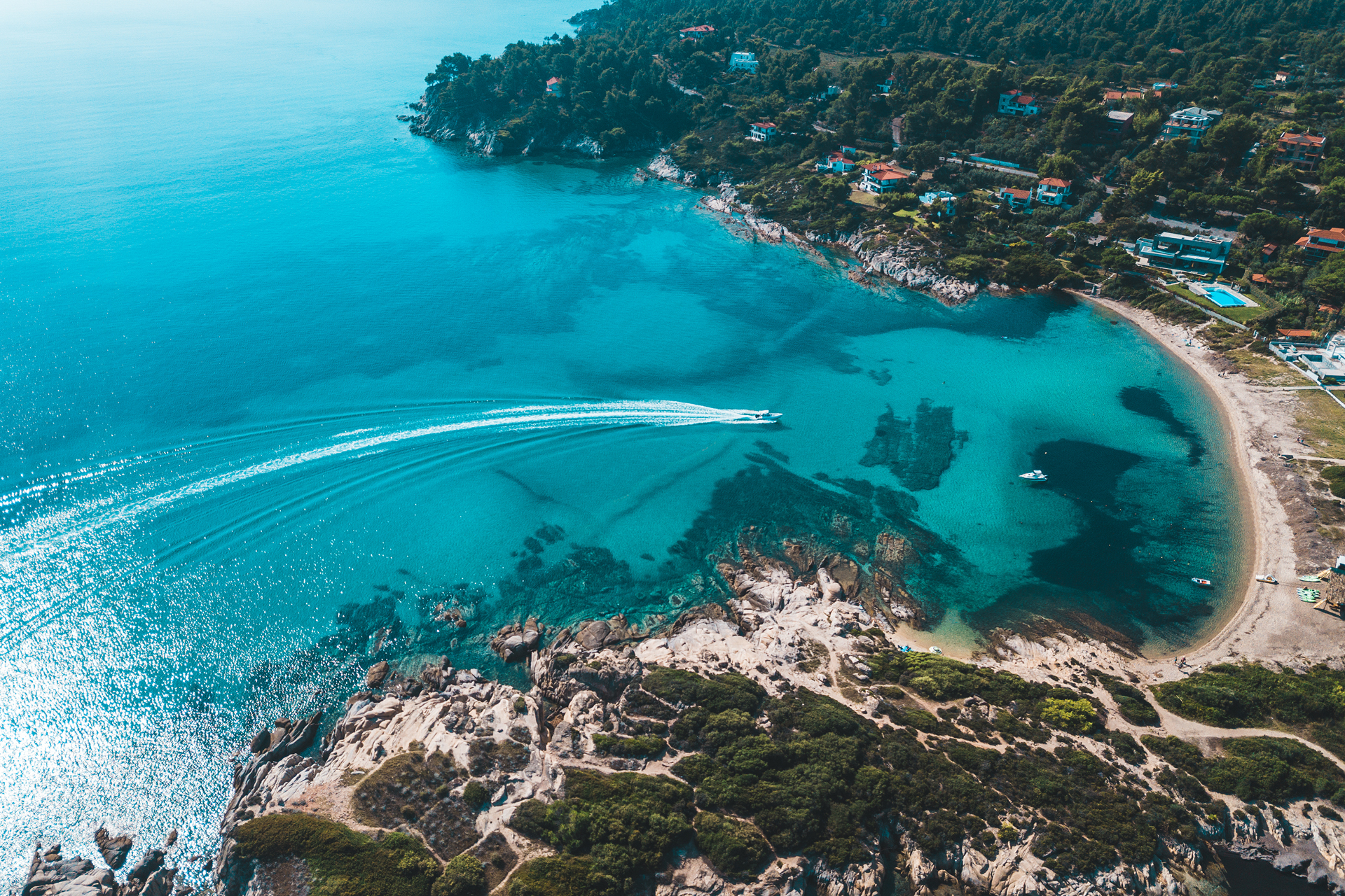 Aerial view of the coastline in Halkidiki with a boat returning to shore