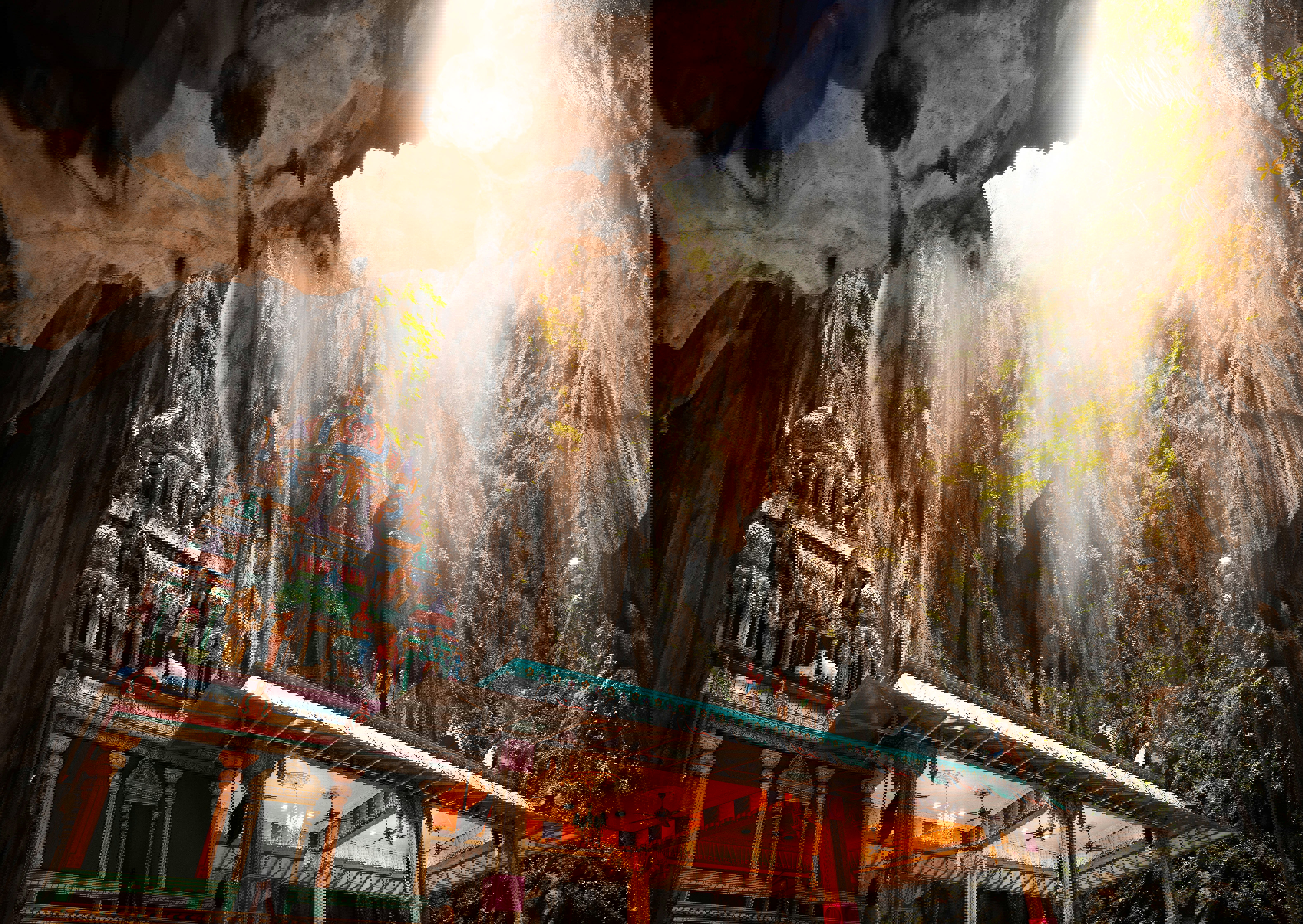 The roof of the temple in the Batu Cave with the towering cave wall ascending behind to a wide opening