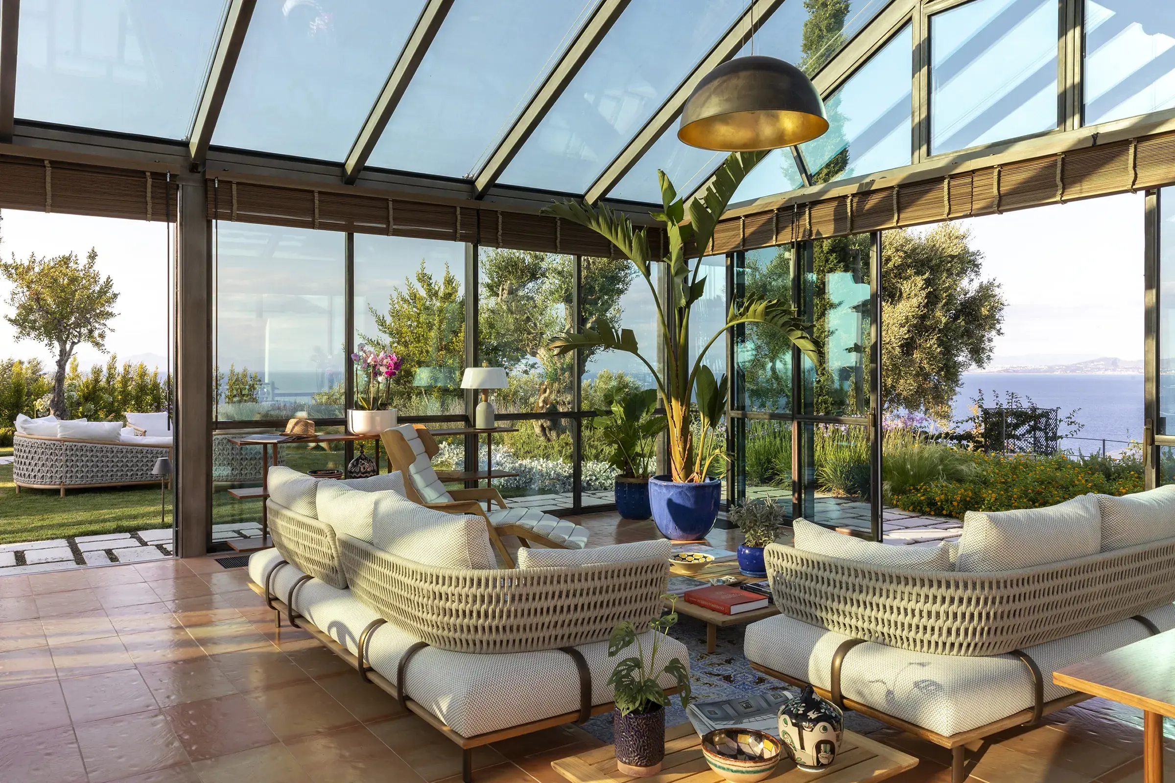 Luxurious sunlit lounge area of the glass-walled Lighthouse Suite with panoramic sea views at San Montano Resort, Ischia.
