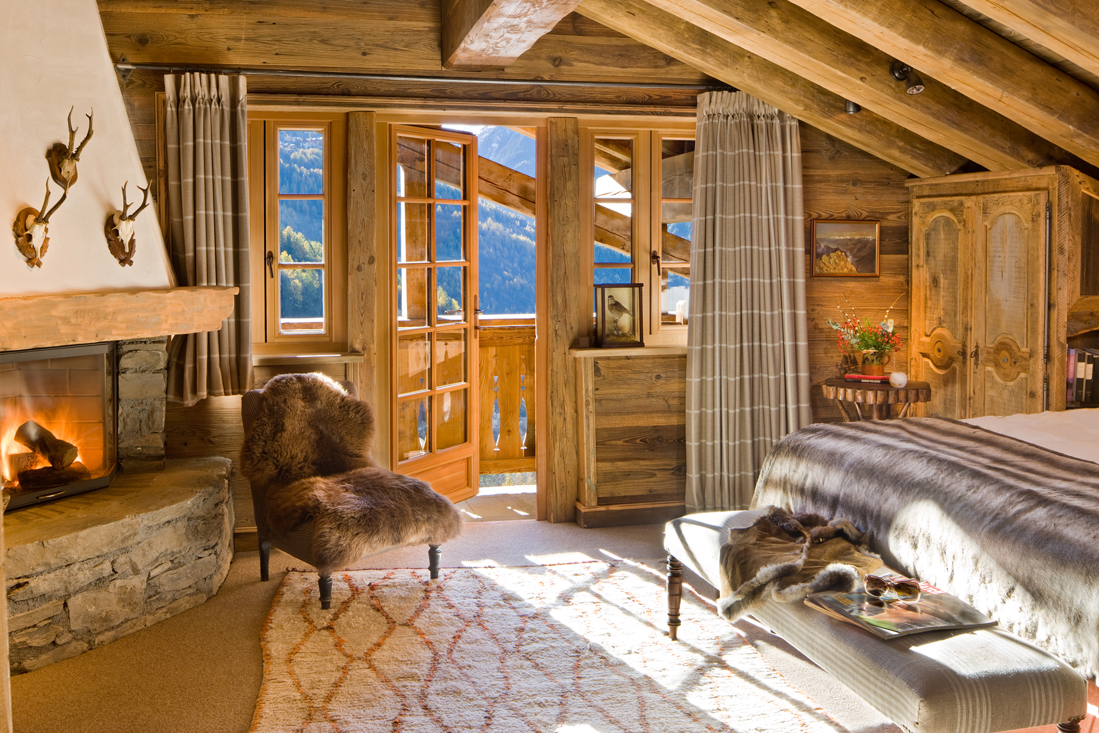 Wooden chalet bedroom with a balcony and fireplace