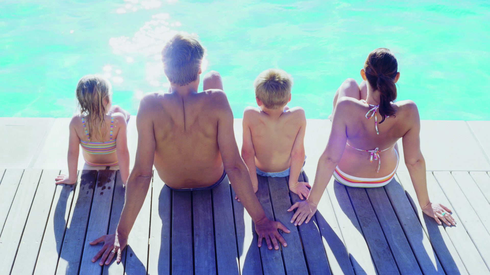 Family sitting next to a pool