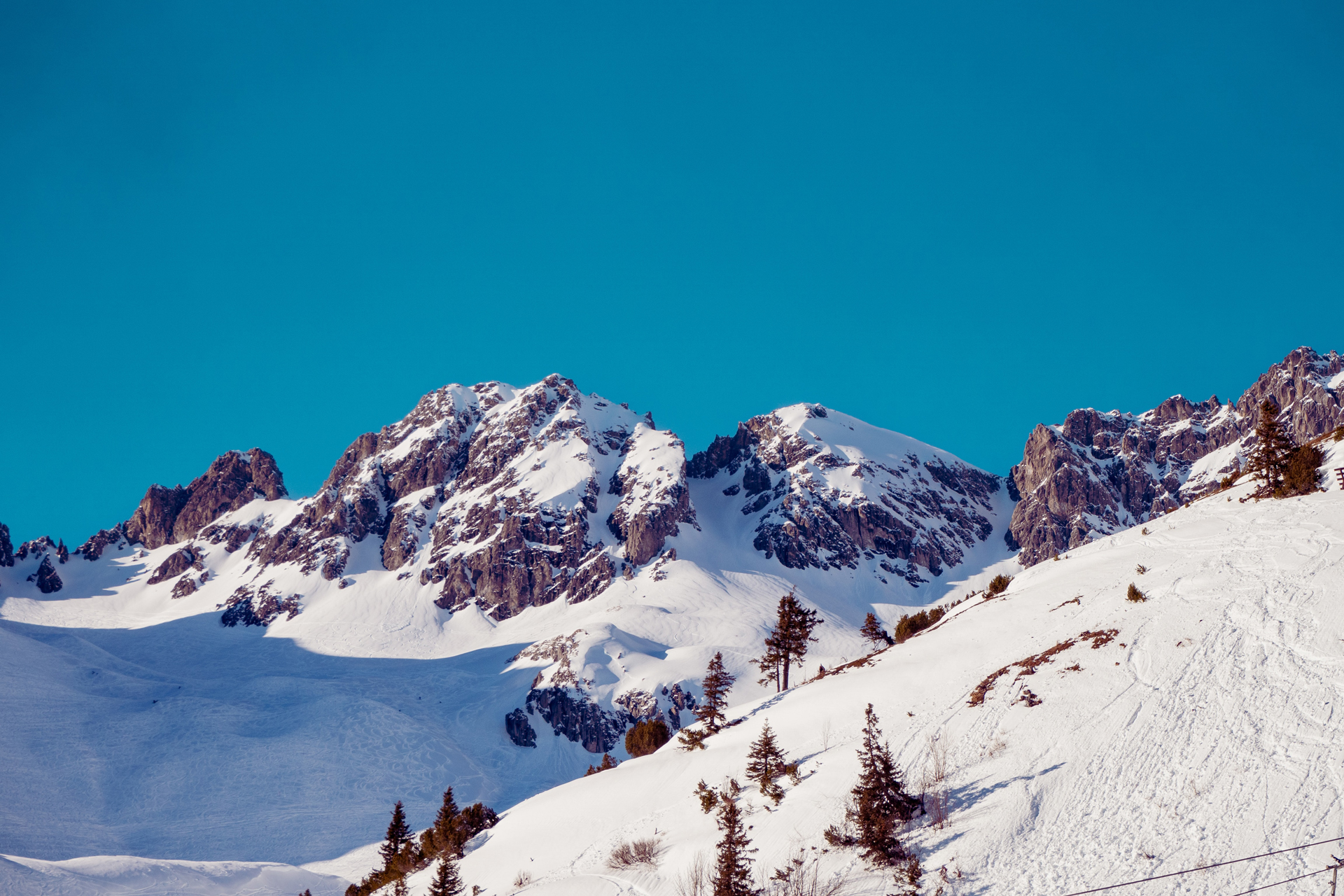 A rocky mountain covered in snow under a blue sky
