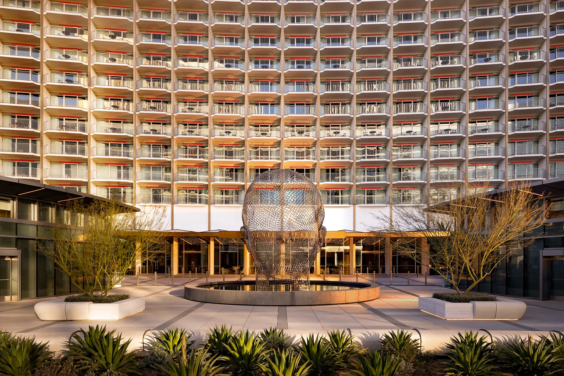 Exterior view of Fairmont Century Plaza in Los Angeles featuring the hotel’s iconic curved façade and central outdoor sculpture.