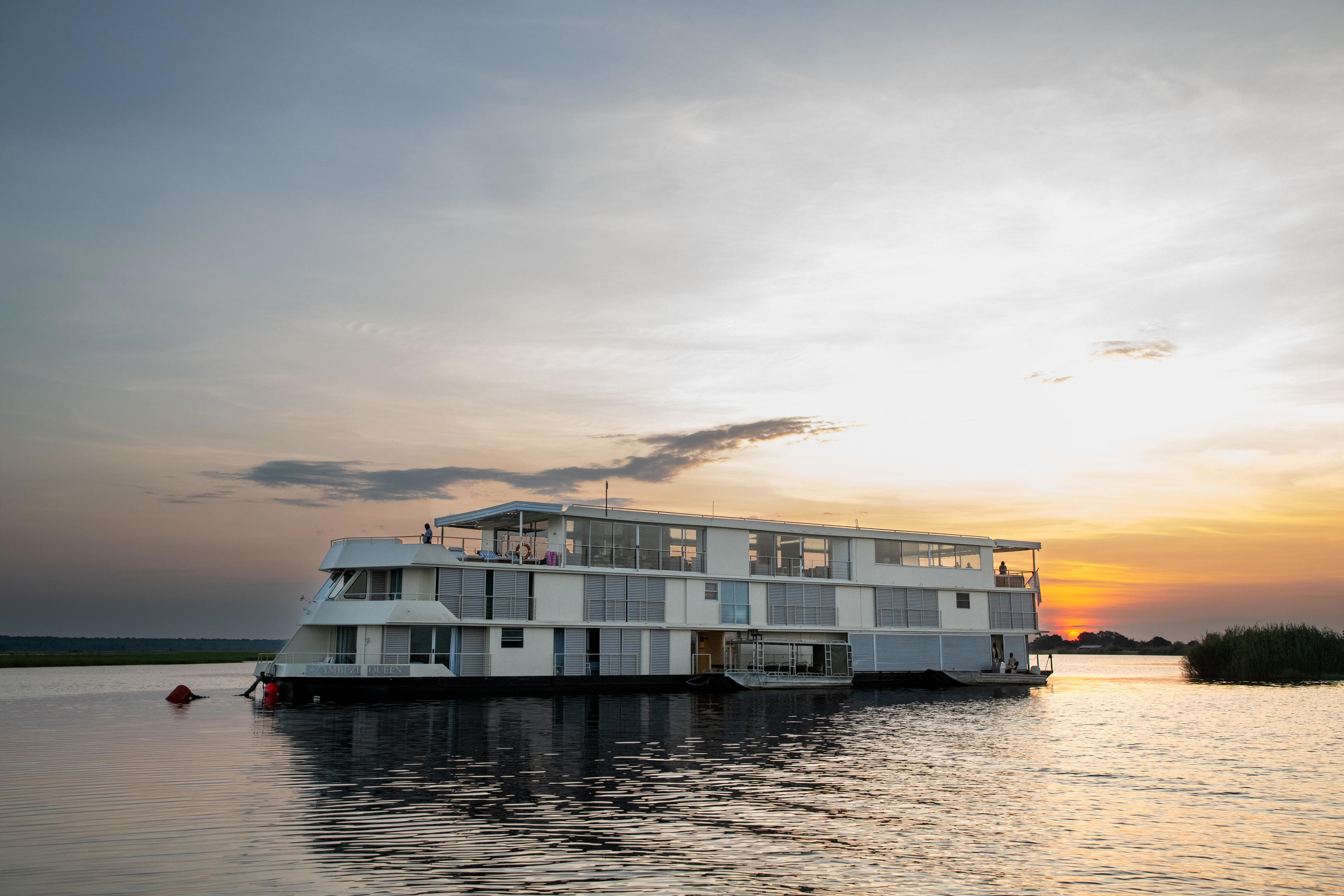 Small river cruise ship Zambezi Queen on the Chobe River at sunset
