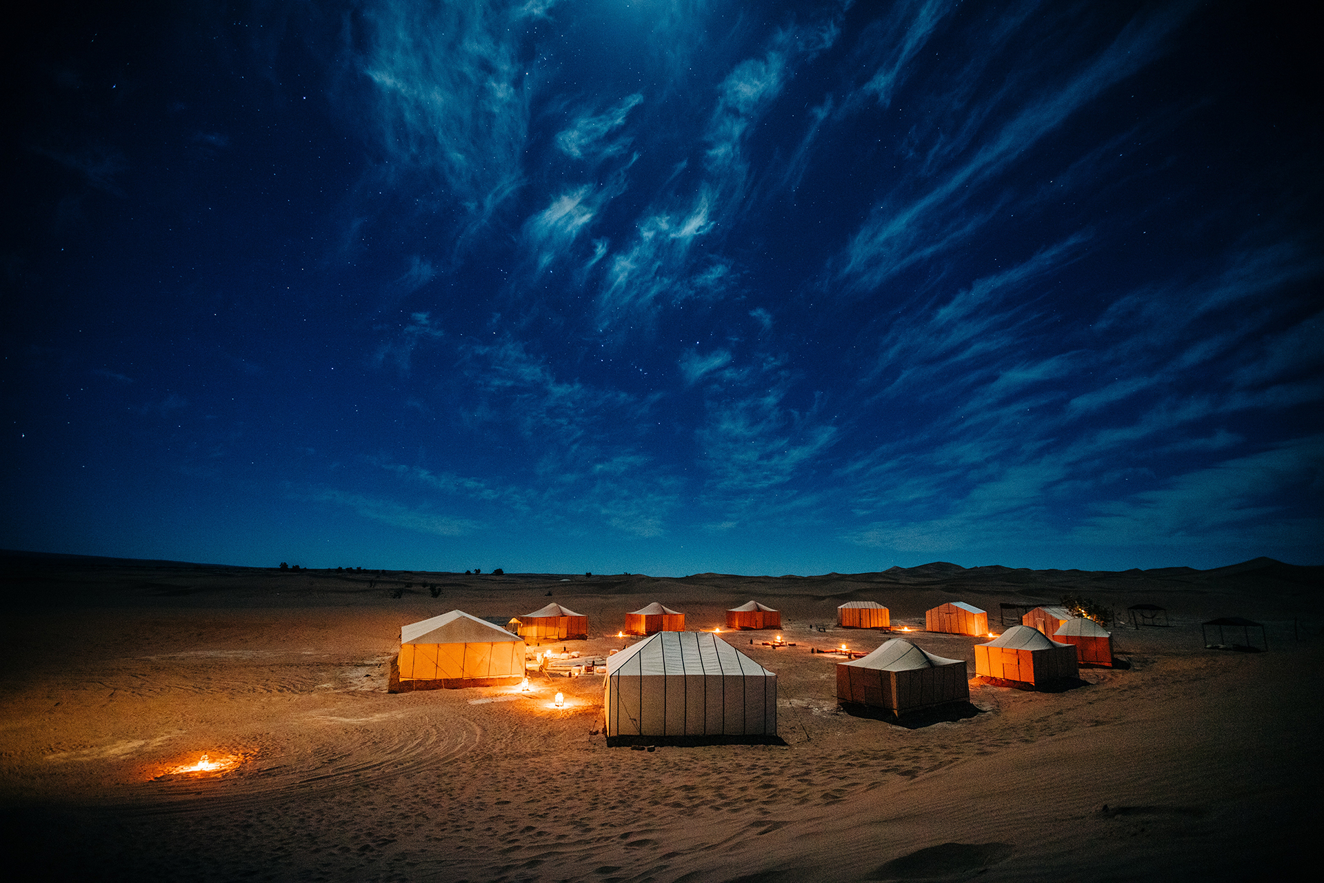 Camp tents under a dark blue sky