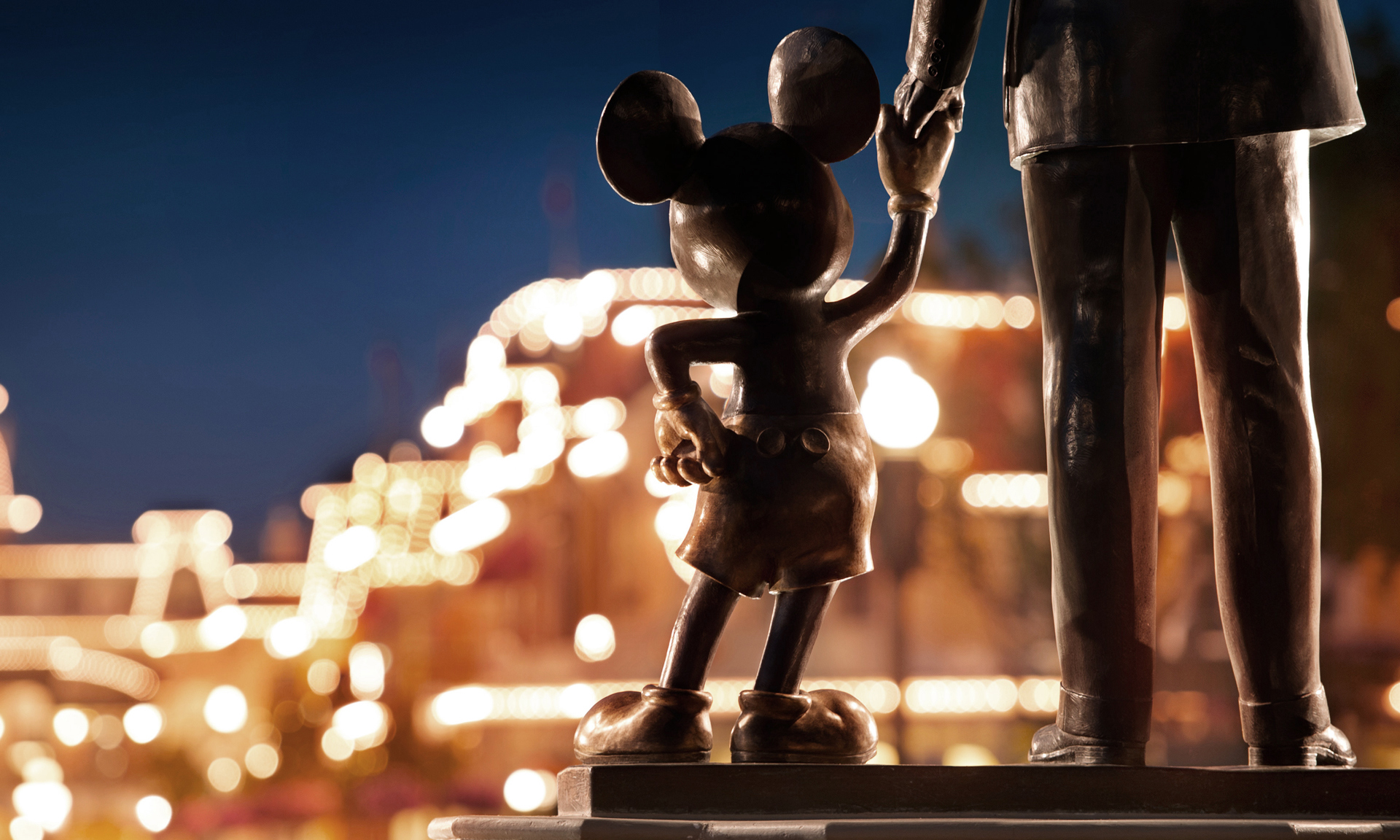 Copper statue depicting Walt Disney holding the hand of Mickey Mouse