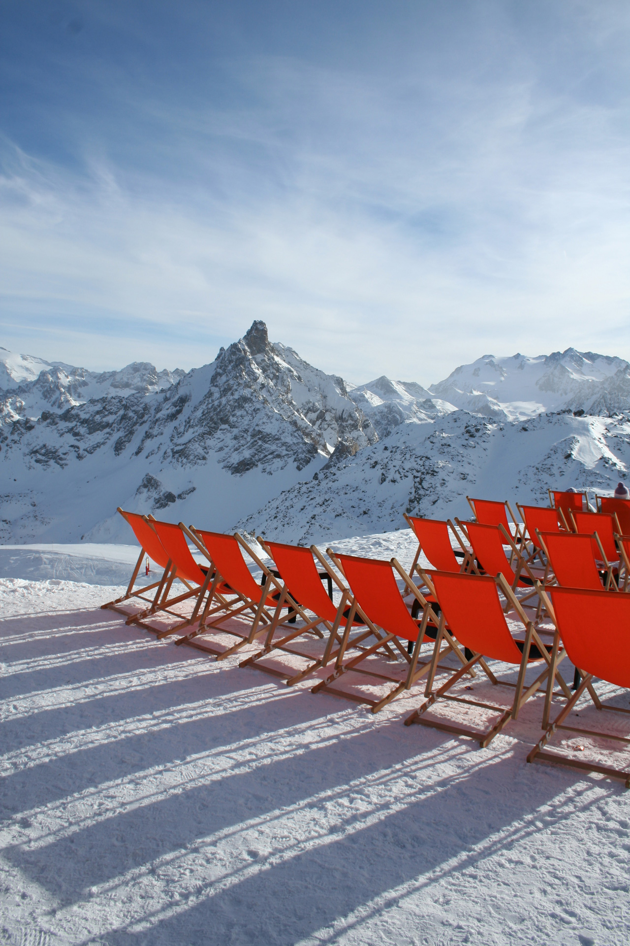 Orange deckchairs on a snowy mountain