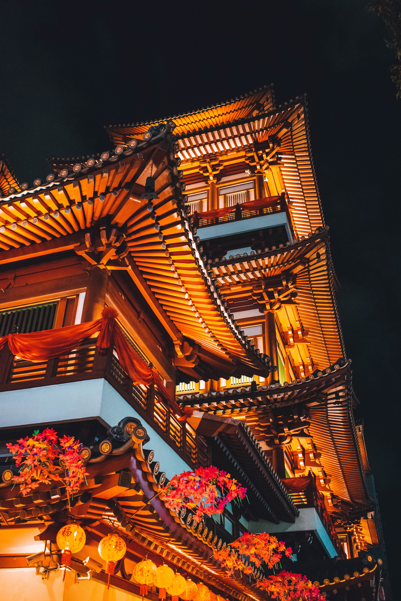 Looking up at a tall temple that is lit up at night