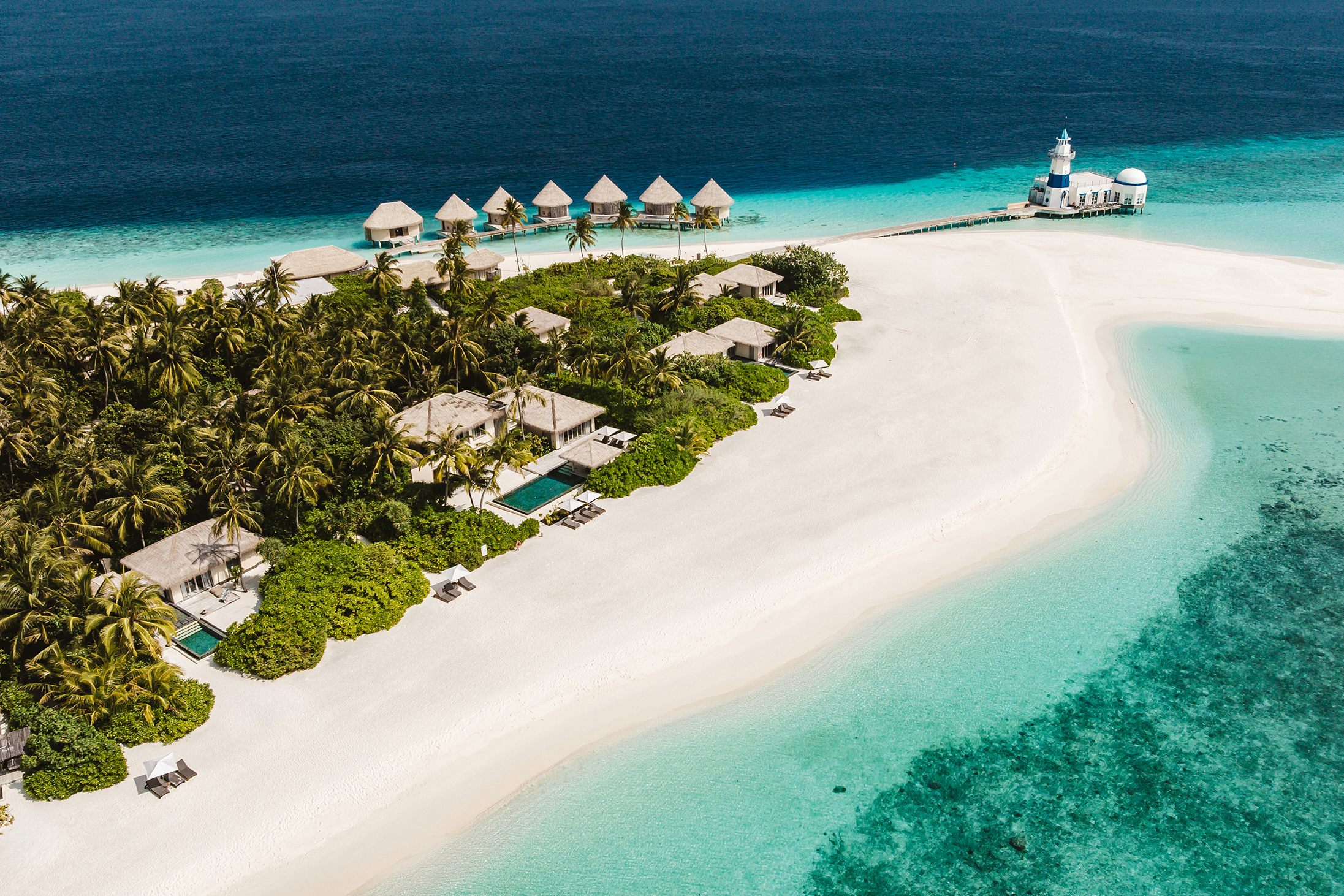 Aerial view of InterContinental Maldives resort featuring overwater villas, beachfront villas, lush greenery, and turquoise waters.