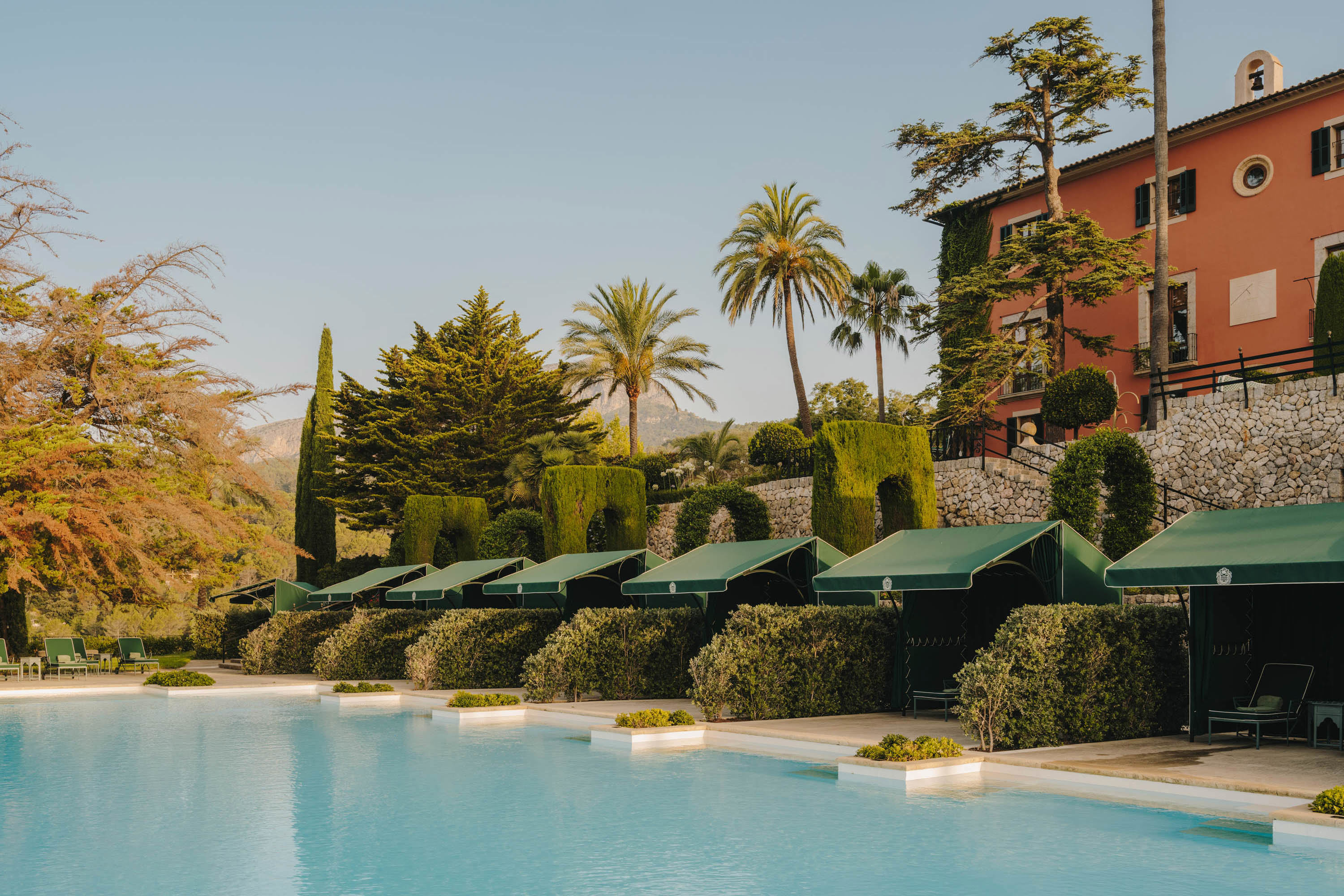 Green cabanas lined up by the pool in front of Son Net