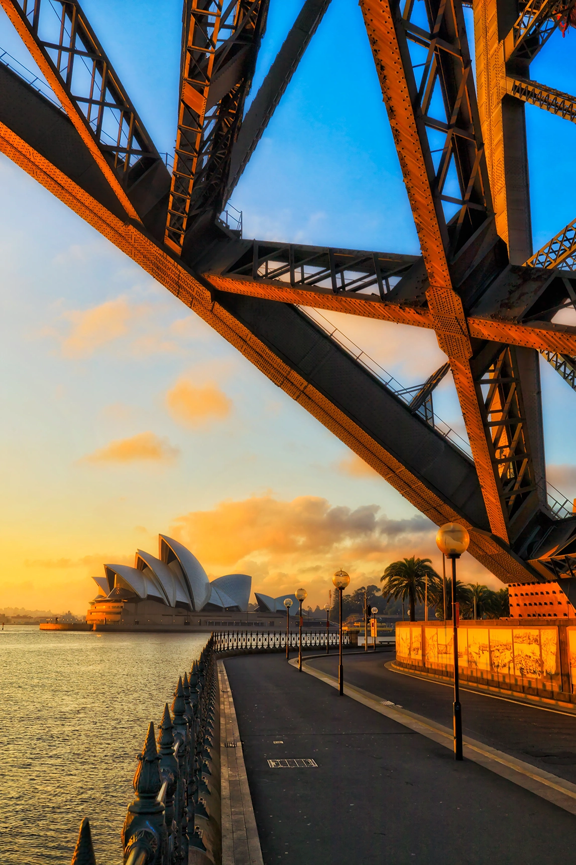 View of Sydney Opera House from under a bridge at sunrise