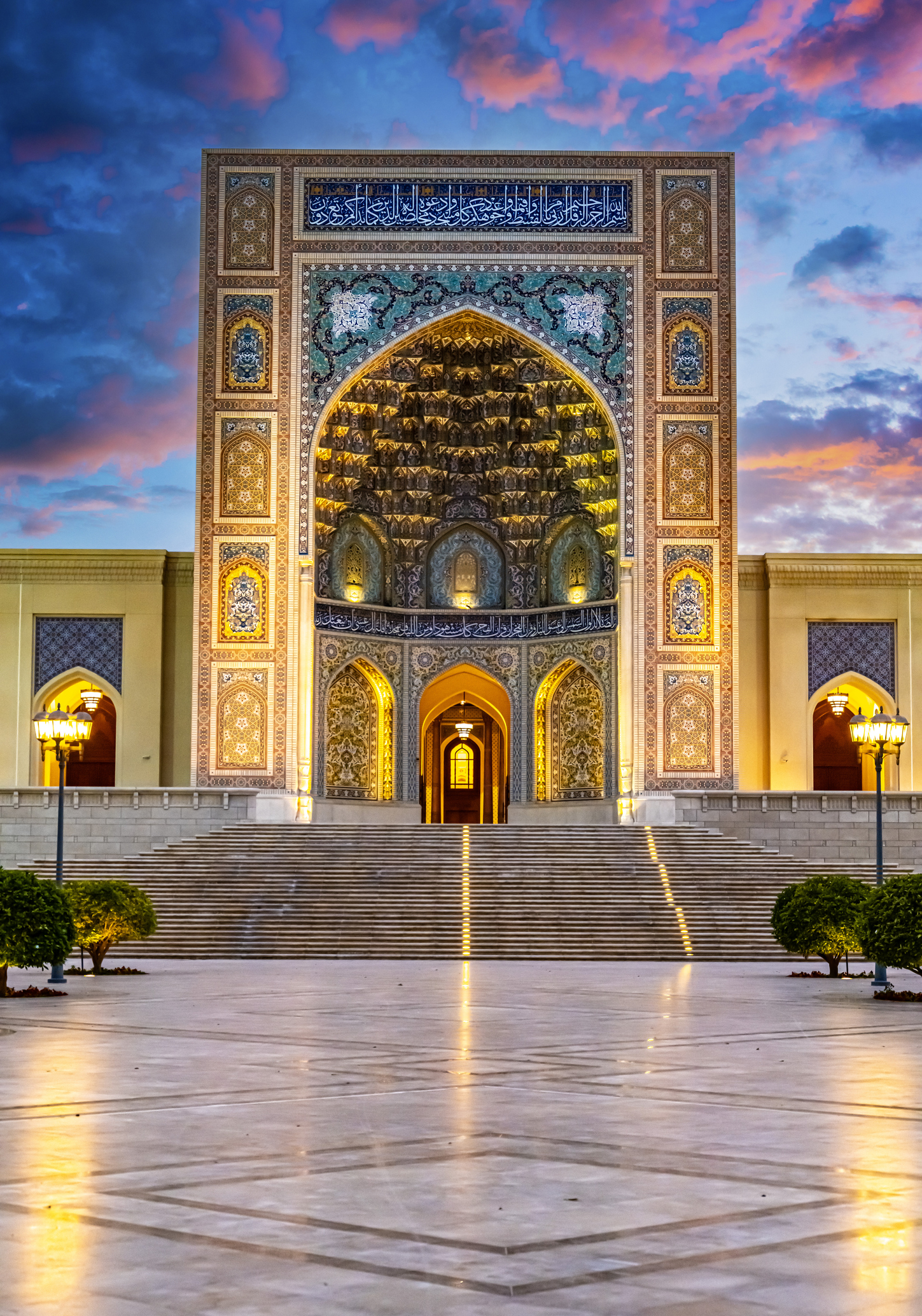 Sultan Qaboos Grand Mosque in Sohar, Oman in the evening, with pretty lights illuminating to ornate Omani facade
