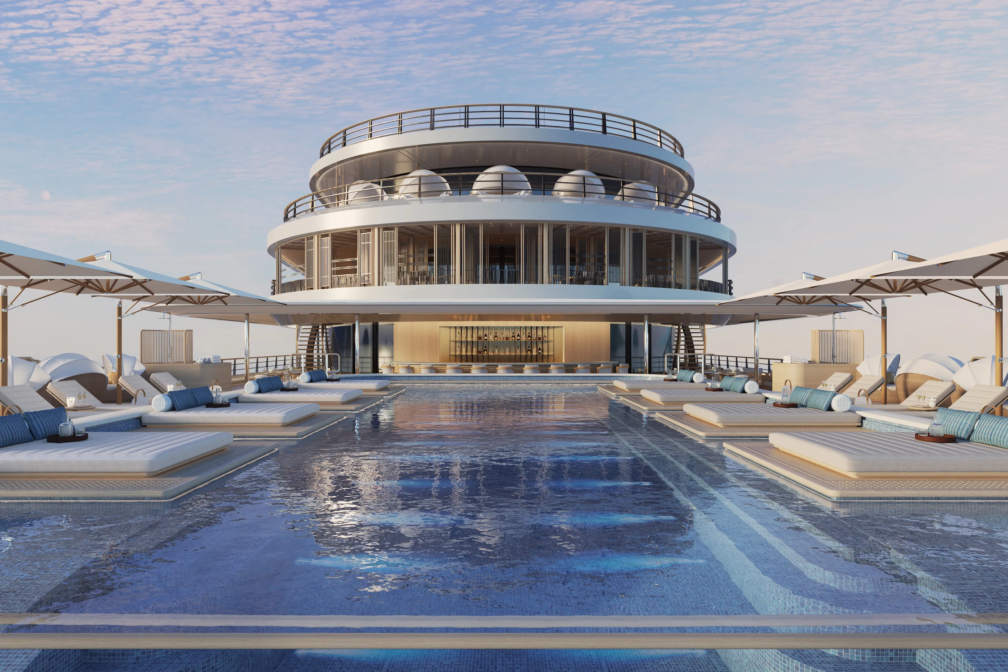Pool aboard Amangati lined with sun beds and umbrellas looking towards the pool bar and upper decks of the yacht