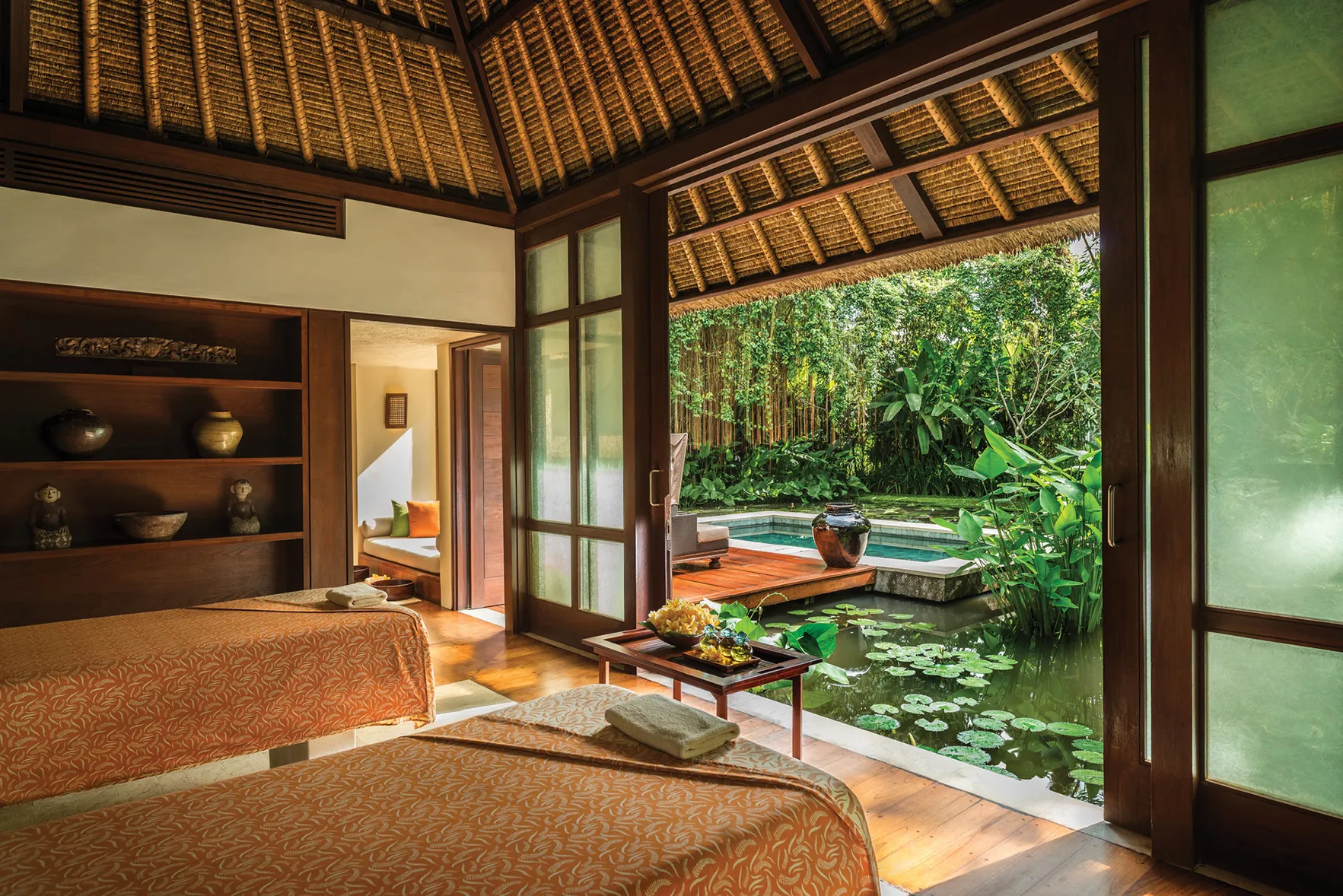 A spa treatment room for two at Four Seasons Resort Bali at Sayan, with a pool and pond outside