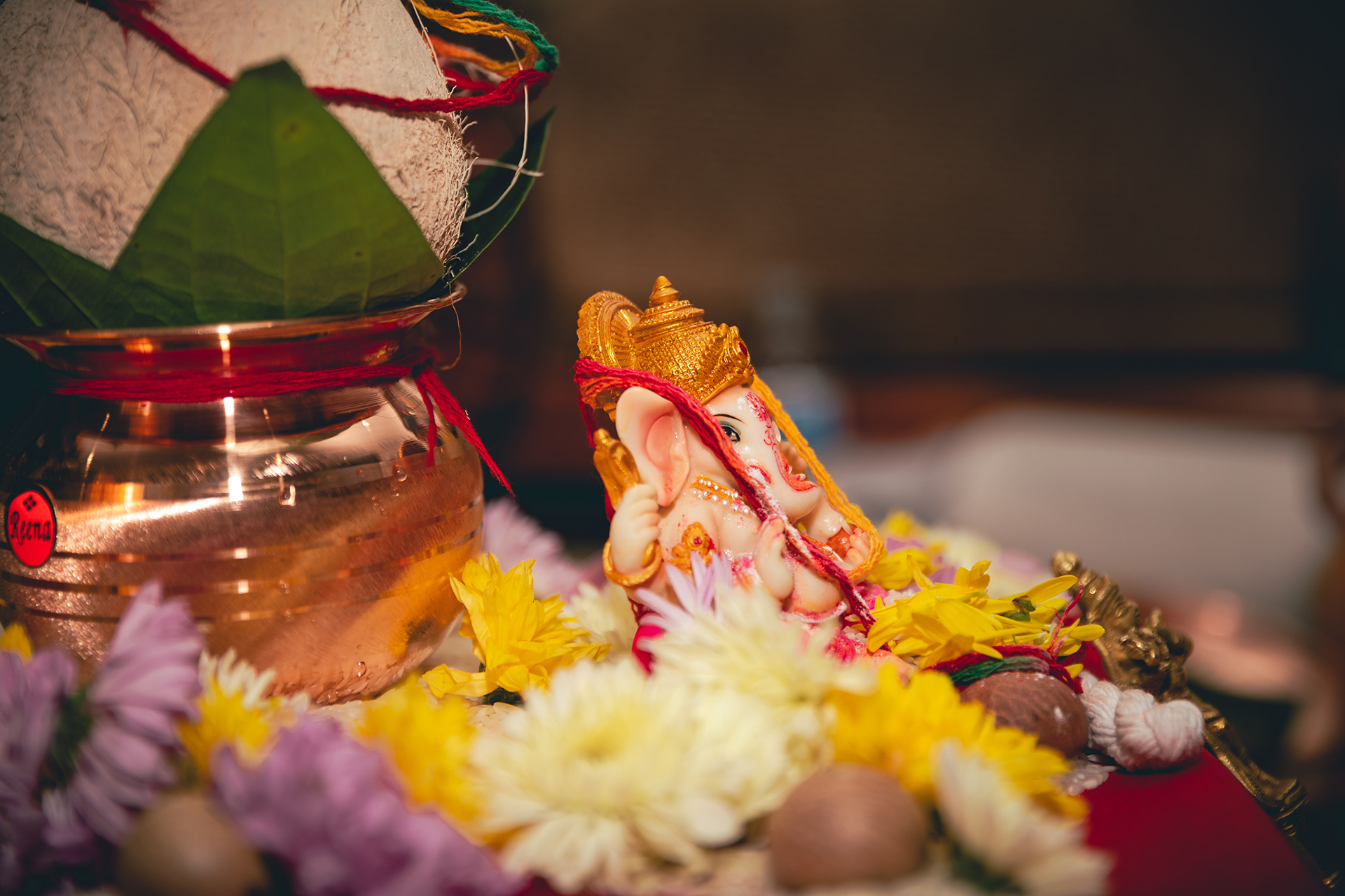 A close up of small colourful flowers with a small ornamental Ganesh