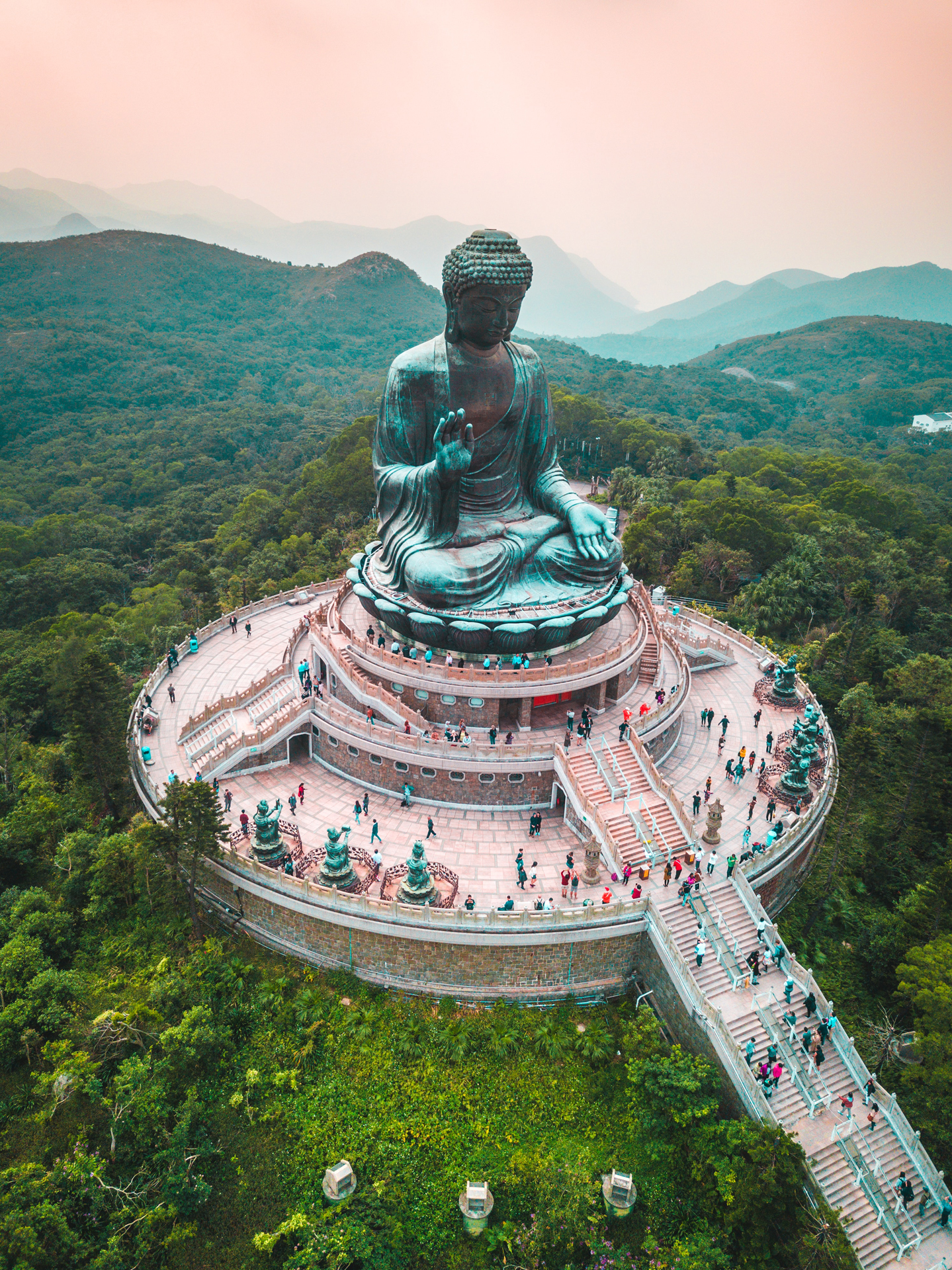 a large statue of a buddha surrounded by trees