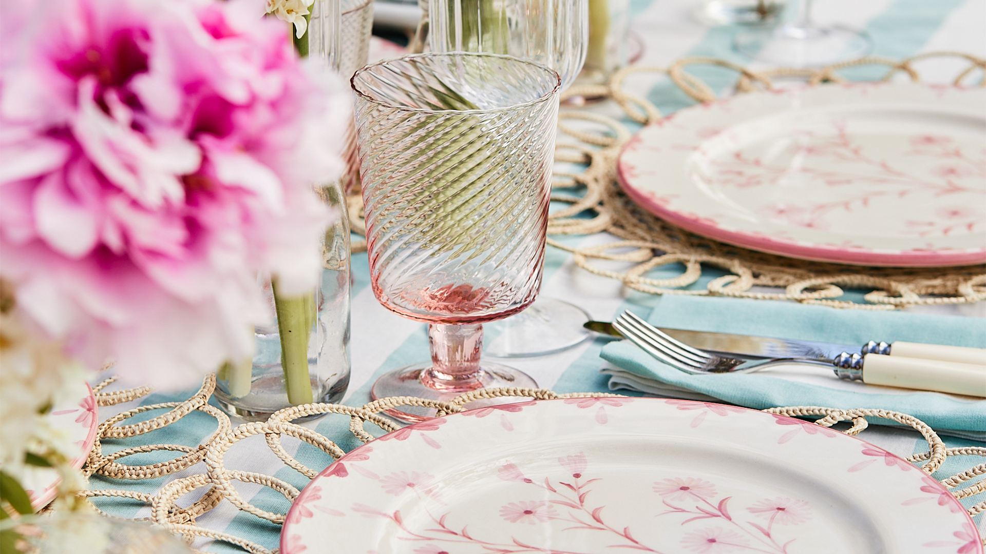 A fancy dining set including an empty glass a plate and cutlery