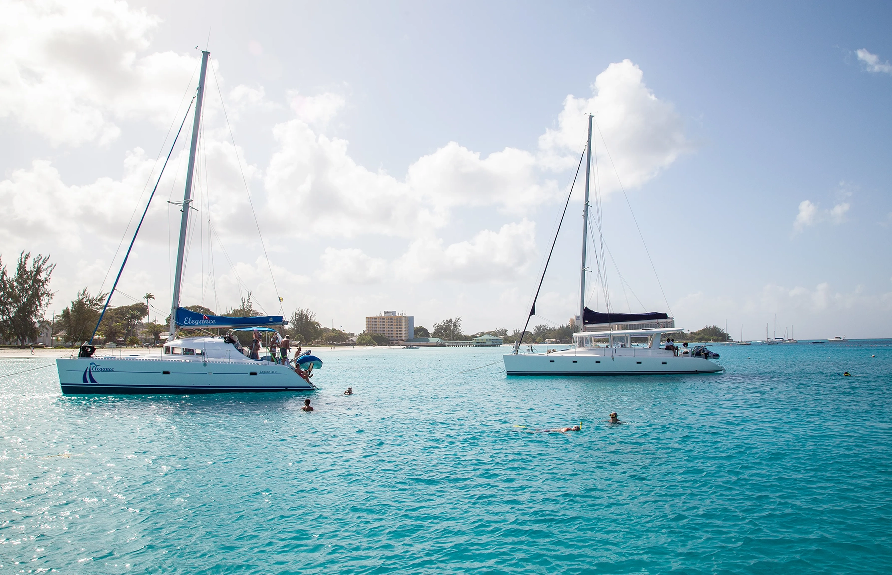 Two boats anchored in Carlisle Bay Barbdaos, with people snorkelling around them