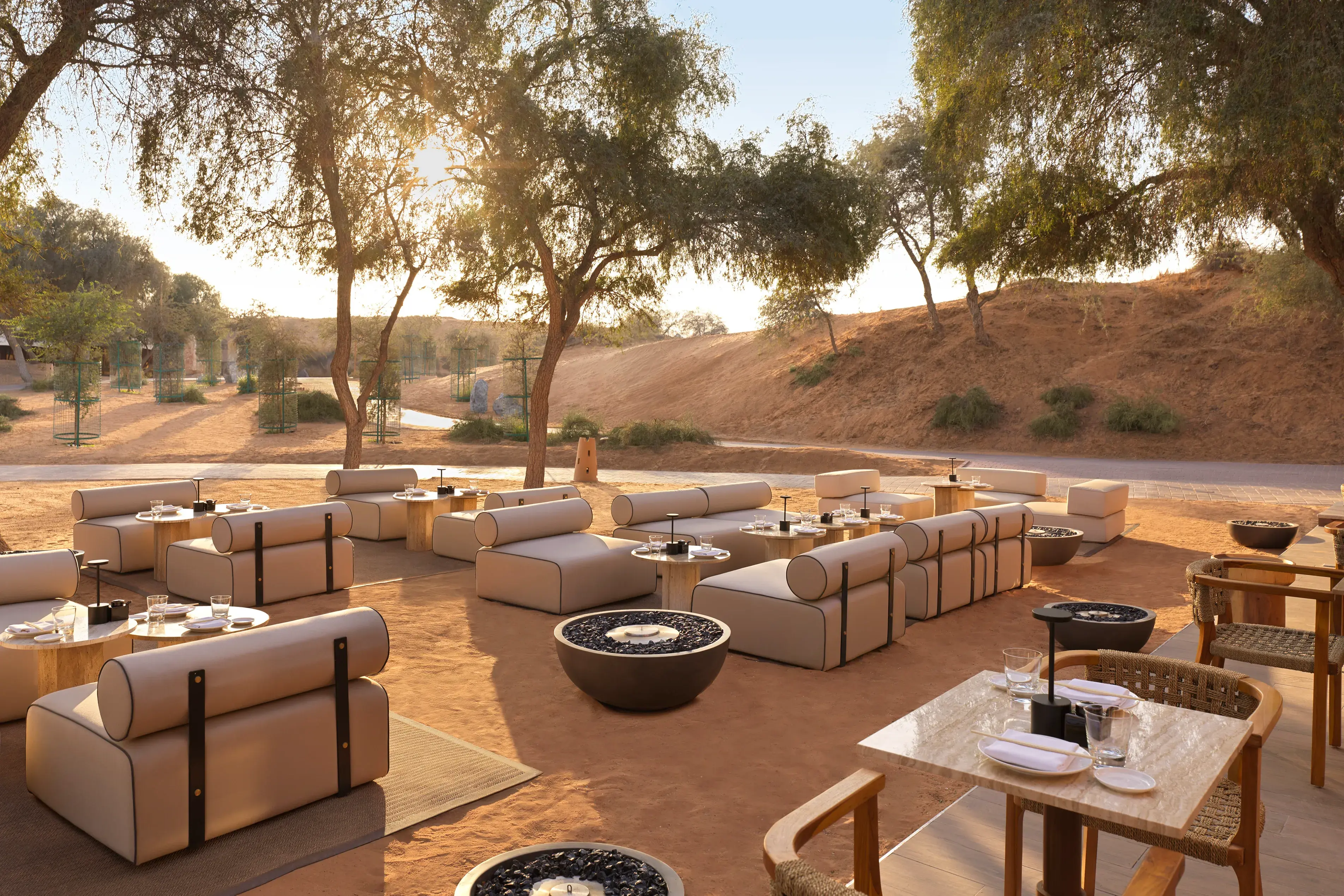 Outdoor desert dining setup with modern lounge seating at The Ritz-Carlton Ras Al Khaimah, Al Wadi Desert.