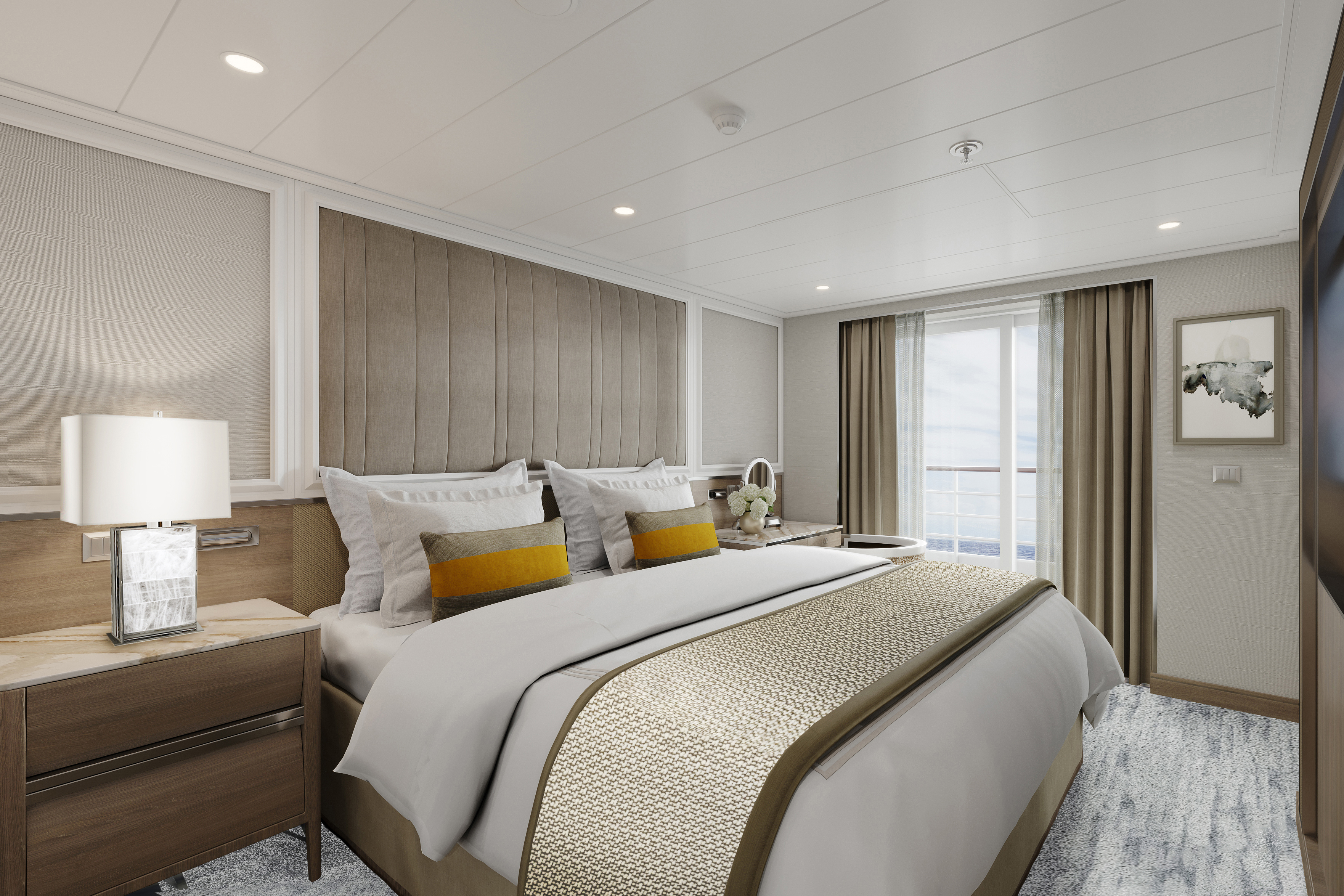 The airy bedroom of a Penthouse decorated in neutral tones with soft furnishings and views of the ocean outside